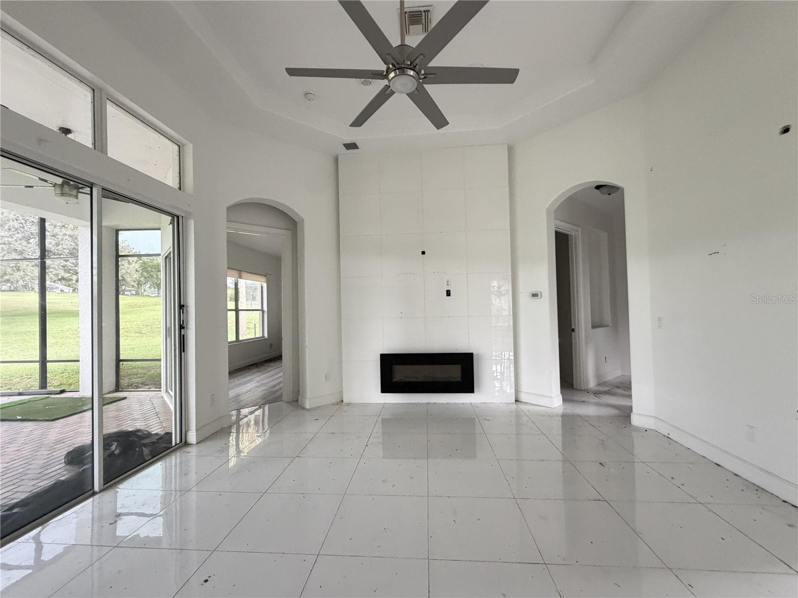 Great room with high ceiling, ceiling fan, and electric fireplace. - 39539 HARBOR HILLS BLVD, LADY LAKE