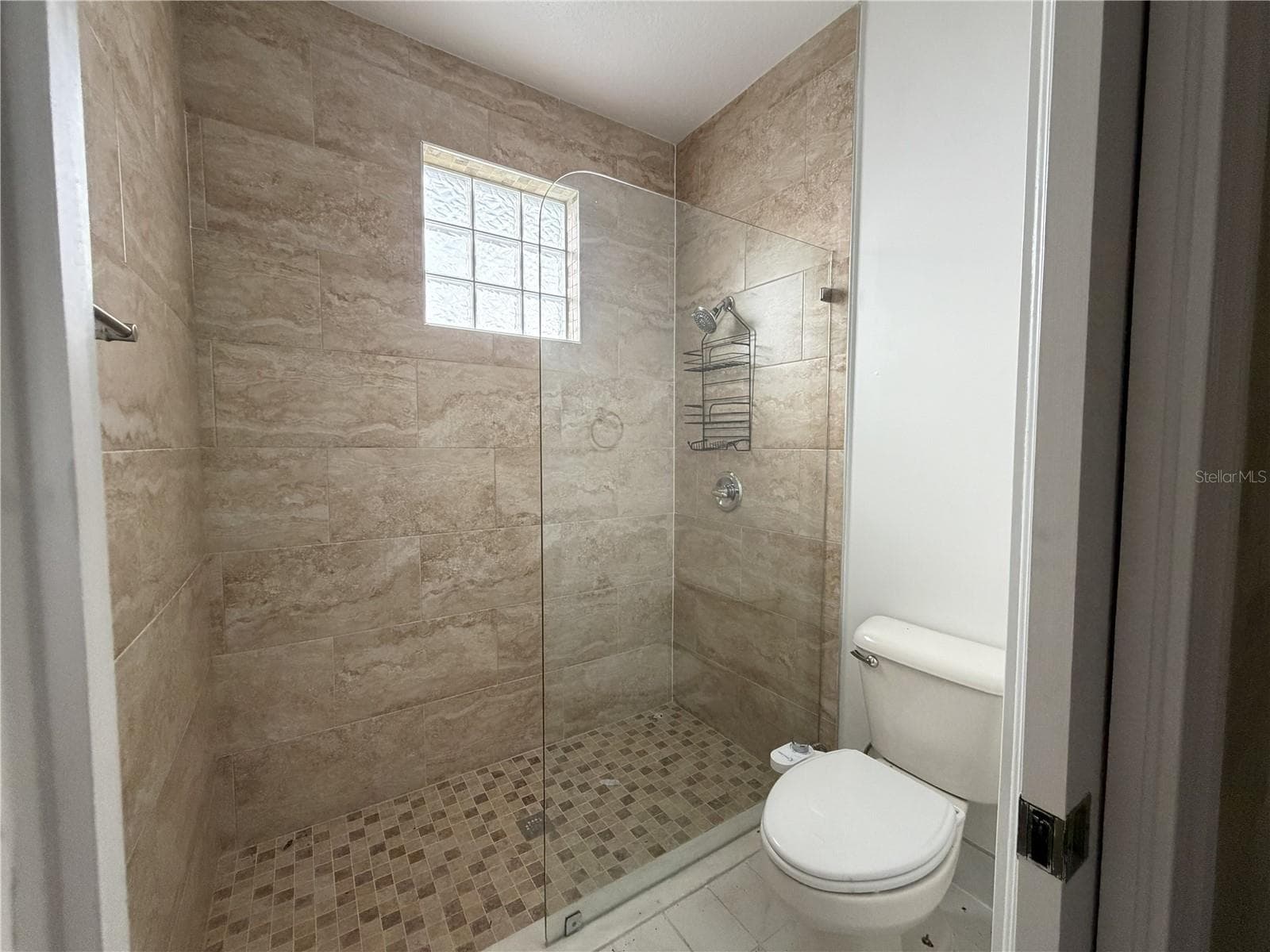 Tiled shower with glass partition and glass-block window. - 39539 HARBOR HILLS BLVD, LADY LAKE