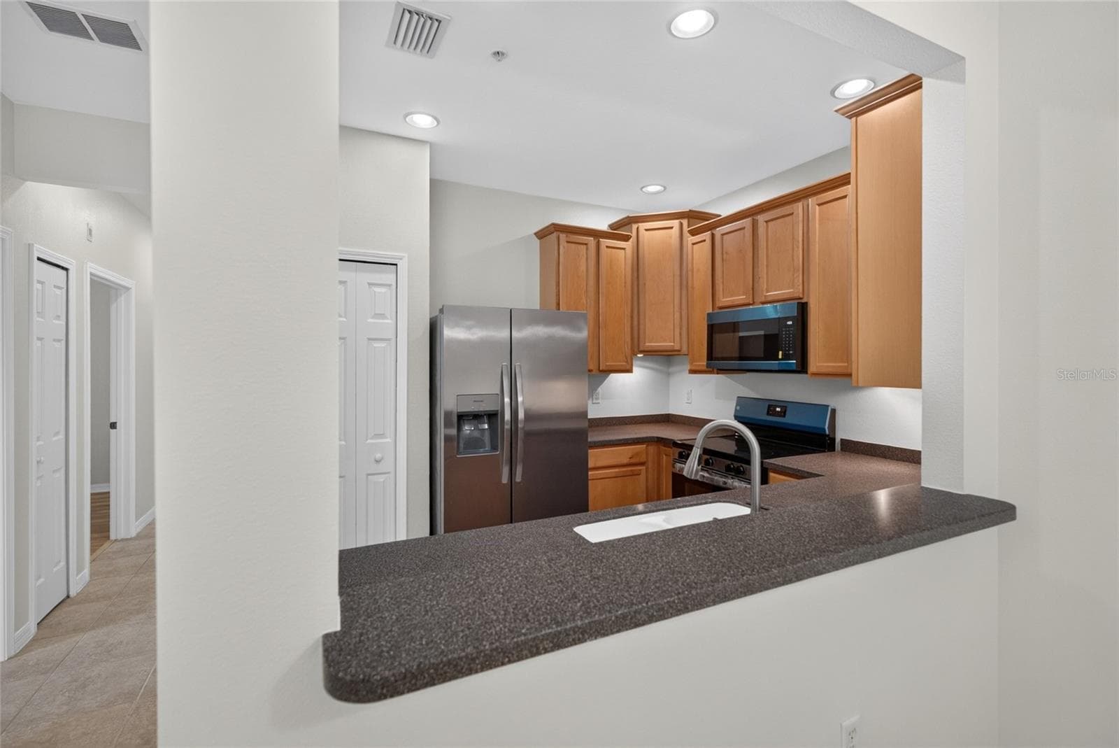 Kitchen with breakfast bar pass-through - 3707 PARKRIDGE CIR #7-106, SARASOTA