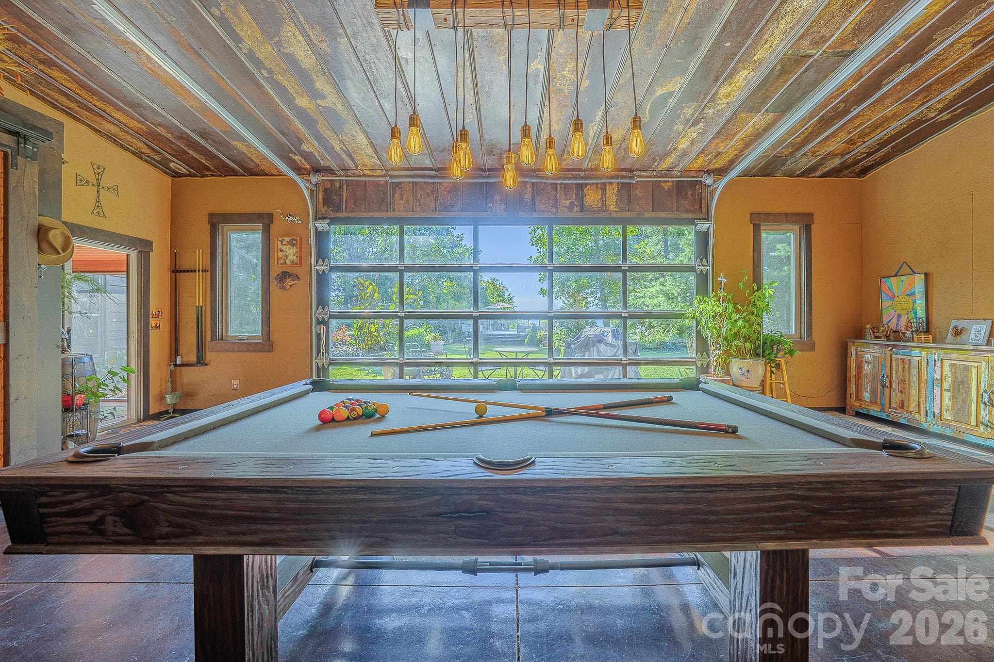 Game on! The recreation room pairs a pool table with long-range mountain views and a glass garage door that brings the outdoors in. - 54 Winning Way, Old Fort