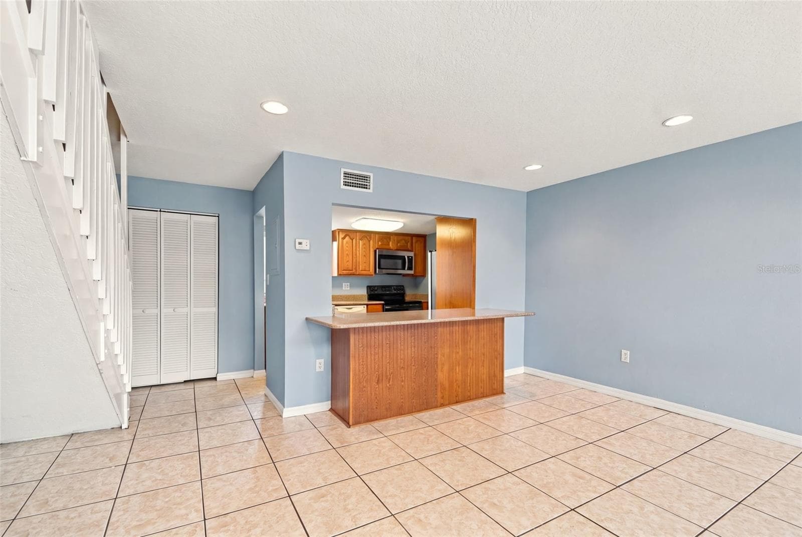 Kitchen counter with stairs to loft on left - 610 ORANGE DR #188, ALTAMONTE SPRINGS