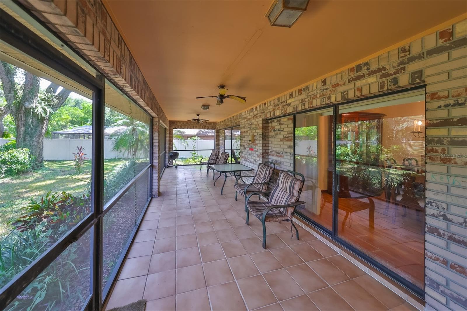 Patio is HUGE with ceiling fans and a view of the vast backyard. - 2609 MANOR OAK DR, VALRICO