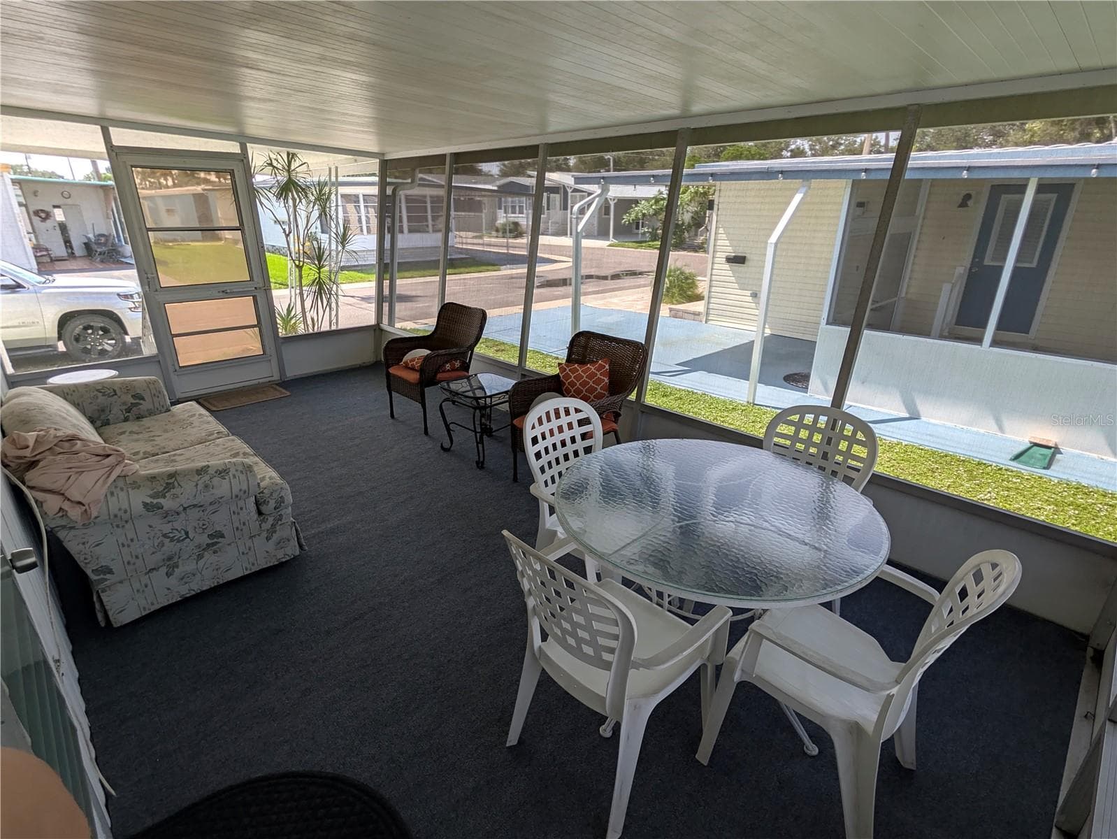 Screen room with new outdoor carpet - 34517 ROSE DR N, PINELLAS PARK