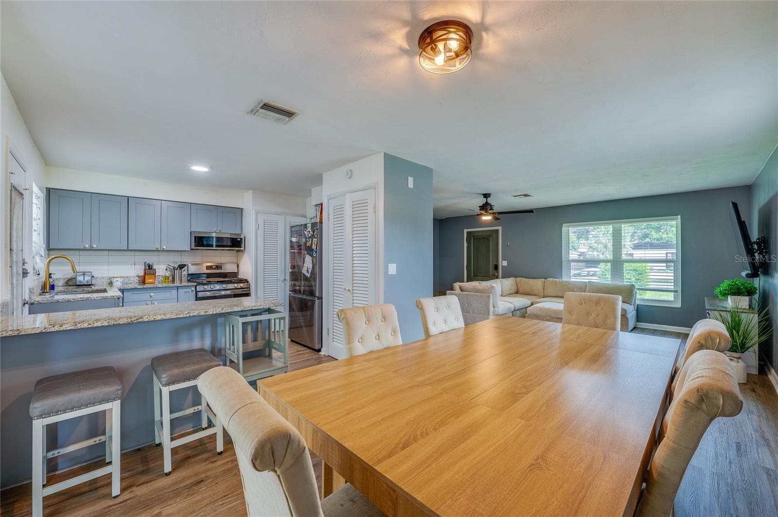 Open-concept floor plan offering seamless flow between the primary living areas, framed by LVP flooring and overhead lighting. - 605 E NORMANDY BLVD, DELTONA