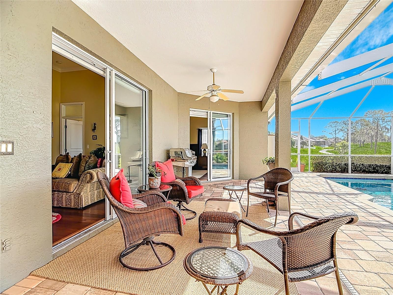 Living room and primary bedroom sliders open to pool - 455 OSPREY LANDING WAY, LAKELAND