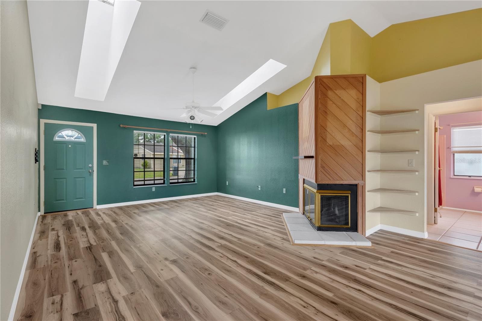 Living Room with wood burning fireplace and built in corner shelves. - 5546 34TH CT E, BRADENTON