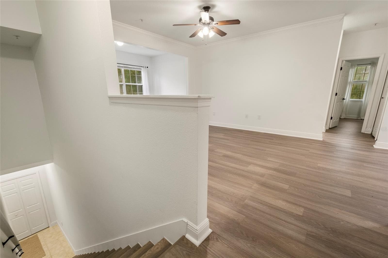The view of the staircase with the steps finished in matching luxury plank vinyl. This lovely home has been updated with a clean, crisp transitional style. - 1300 EASTERN PECAN PL #208, WINTER GARDEN