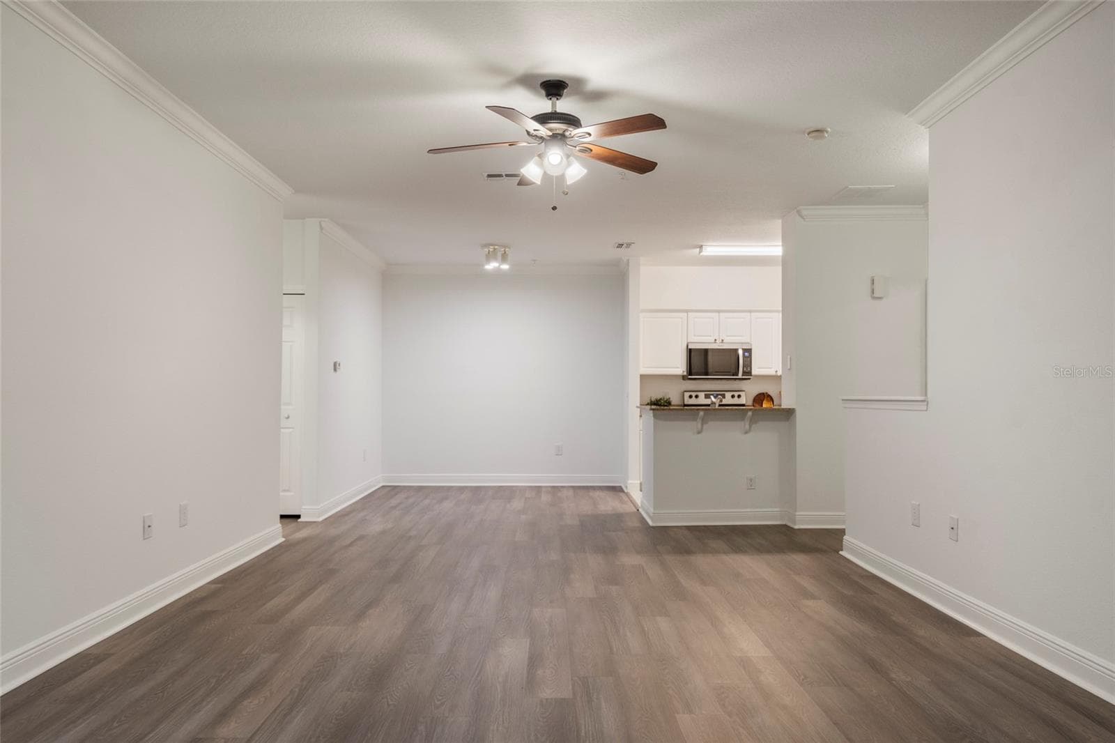 The opposite view from the alcove looking back towards the kitchen with supporting bedrooms to the left. - 1300 EASTERN PECAN PL #208, WINTER GARDEN