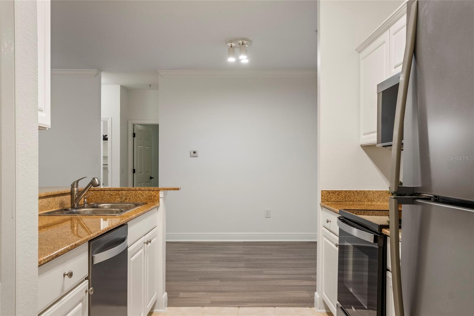 Along with the brand new microwave and refrigerator is a brand new dishwasher. These three appliances have never been used. The doors beyond are to supporting bedrooms. - 1300 EASTERN PECAN PL #208, WINTER GARDEN