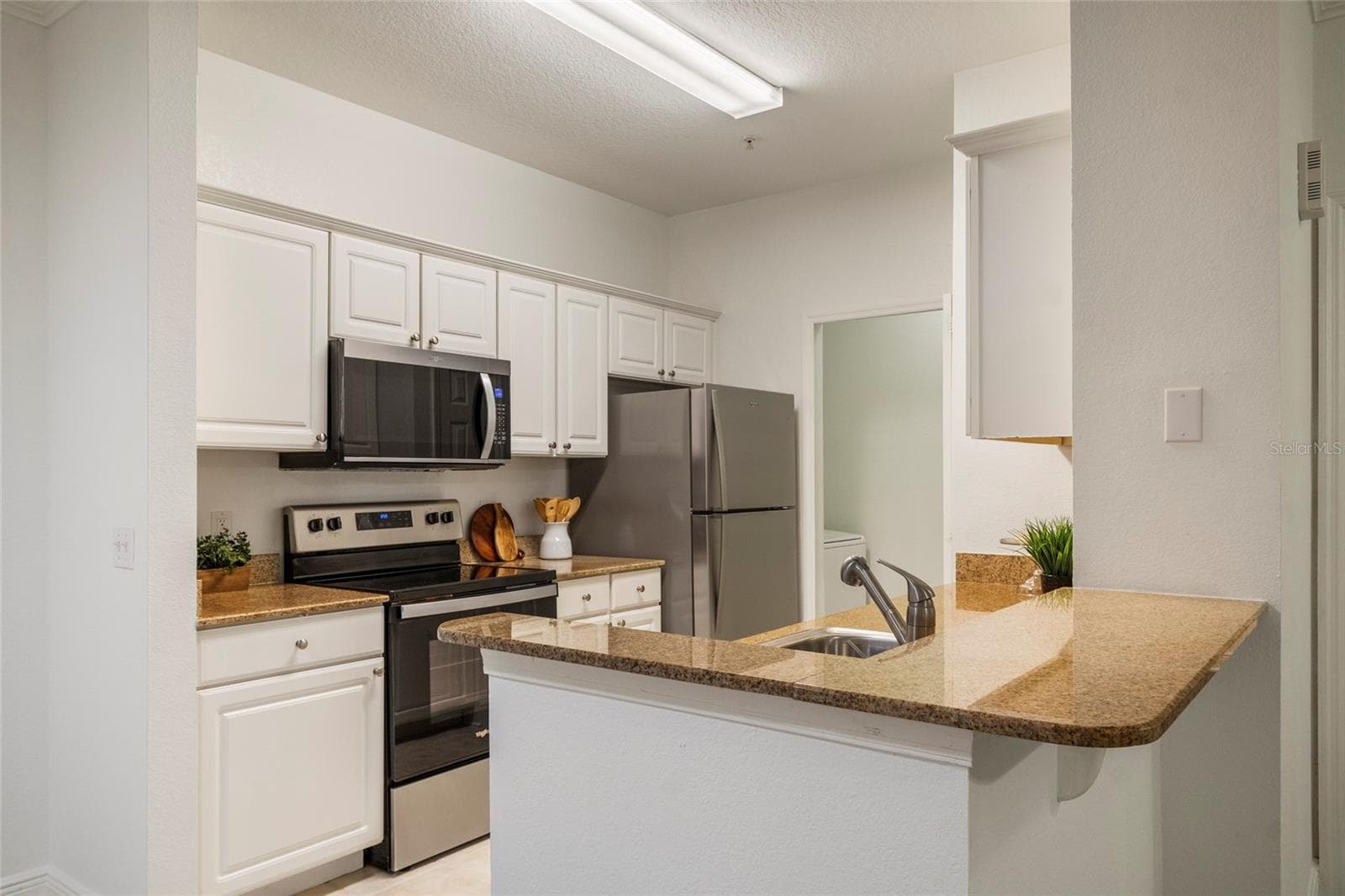 A total of 15 cabinet doors strategically planned to maximize storage, prep space and appliance location in the efficient triangle work space from Range to sink to refrigerator a well planned, minimum steps between work flow in this galley kitchen. The Laundry just a few steps away with its own dedicated space and door. - 1300 EASTERN PECAN PL #208, WINTER GARDEN