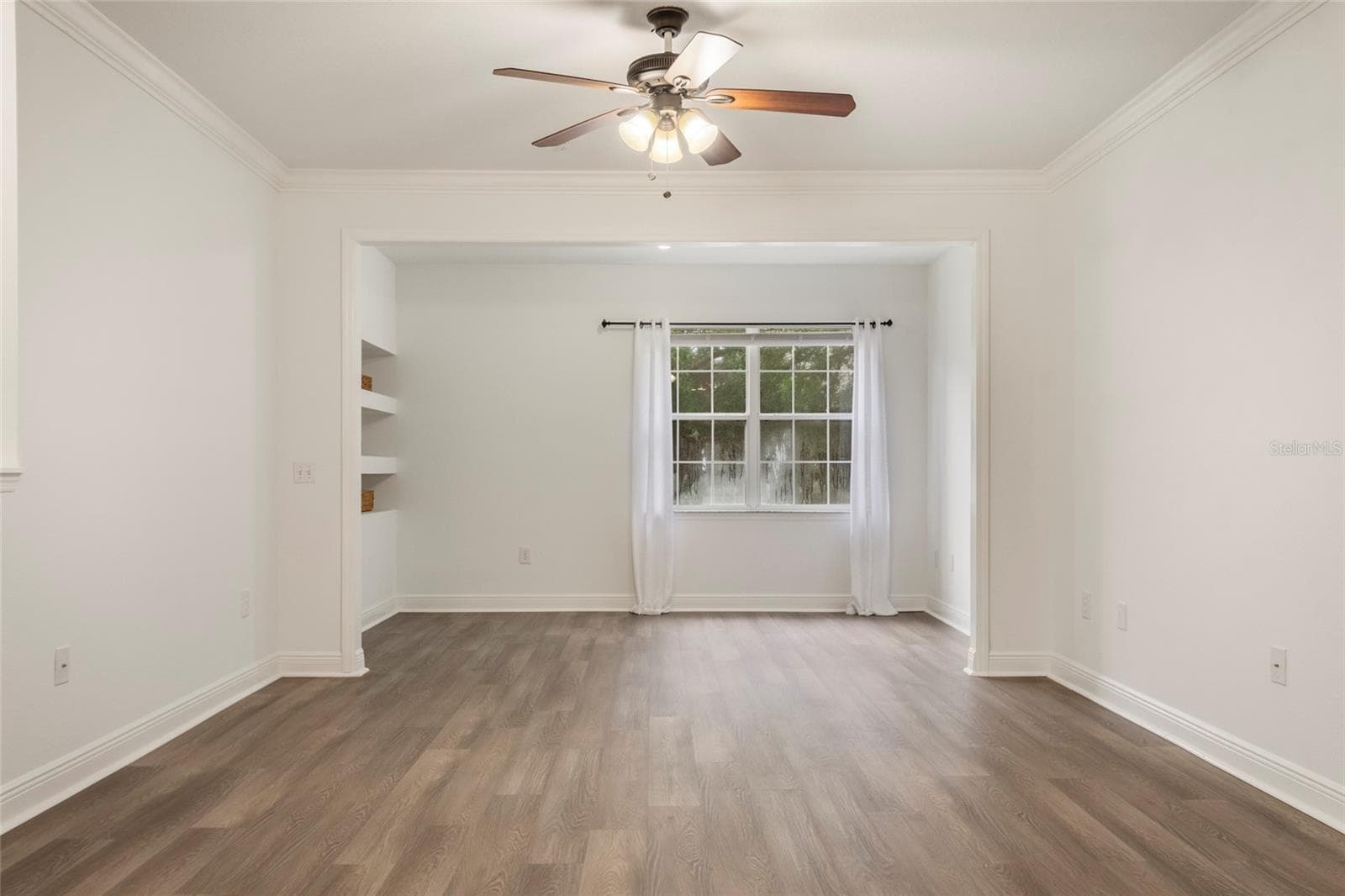 When standing in the dining area a full view of the generously sized family room/alcove room complete with a double window for a lovely view of the mature trees that surround the unit. - 1300 EASTERN PECAN PL #208, WINTER GARDEN