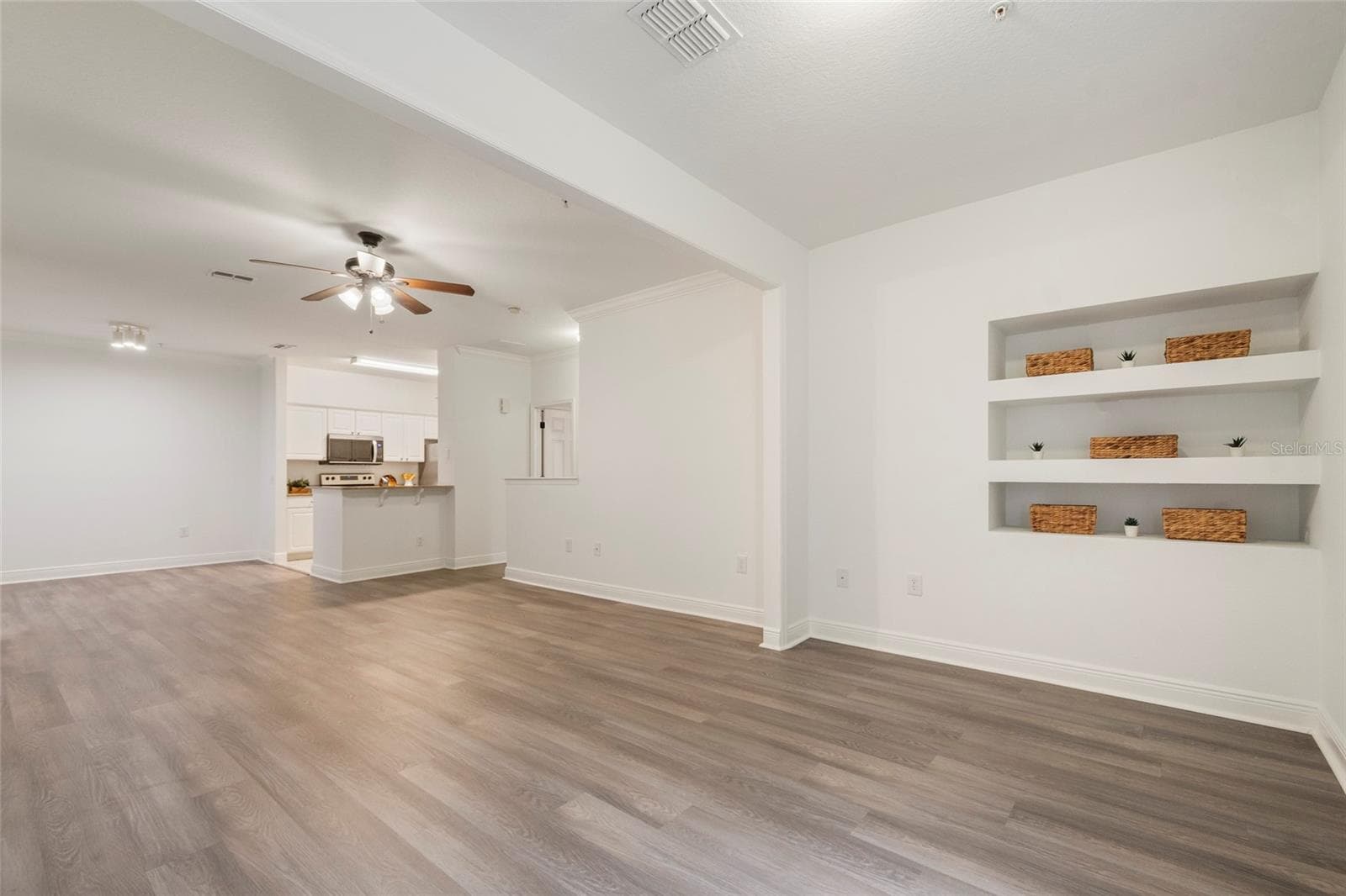 A view from the alcove back into the open concept floor plan. Dedicated space for your dining room table and chairs followed by ample space for family room seating and finished with the alcove area which can extend the family room or become a dedicated office area, work out space or flex room. - 1300 EASTERN PECAN PL #208, WINTER GARDEN