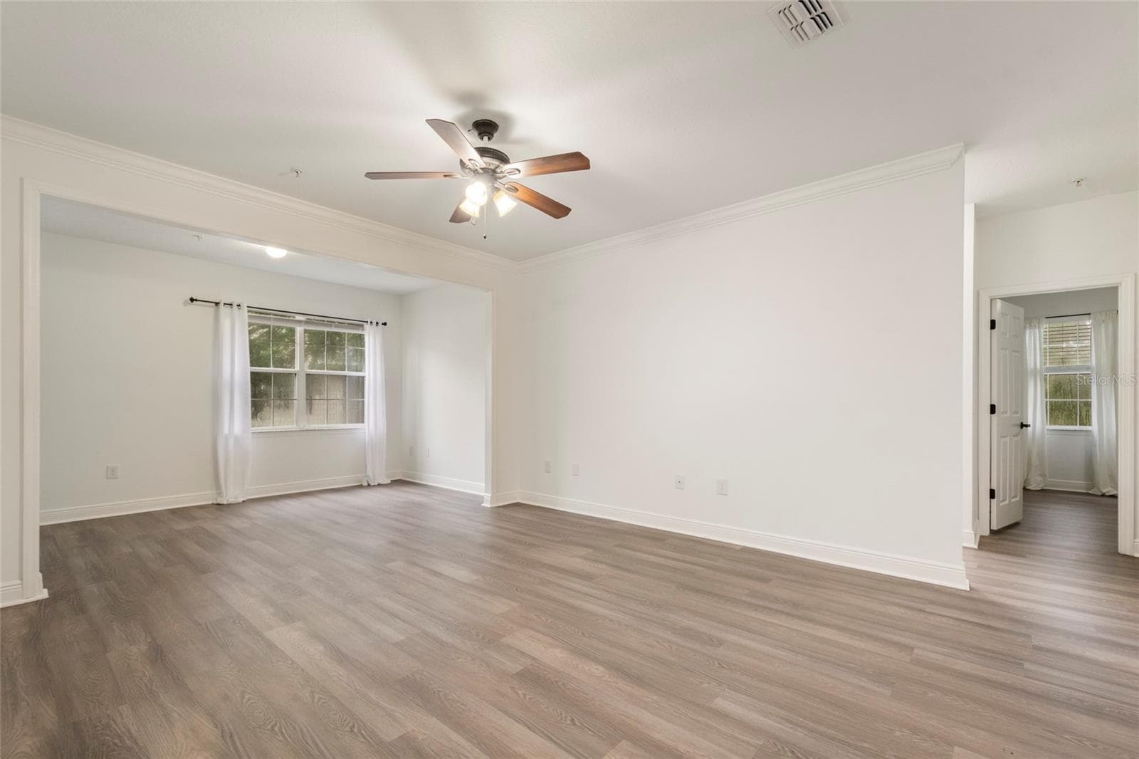 A clear view of the supporting bedroom. The family room also features a lighted ceiling fan, drapery rods( drapes do not convey) and a dedicated light in the alcove area. - 1300 EASTERN PECAN PL #208, WINTER GARDEN
