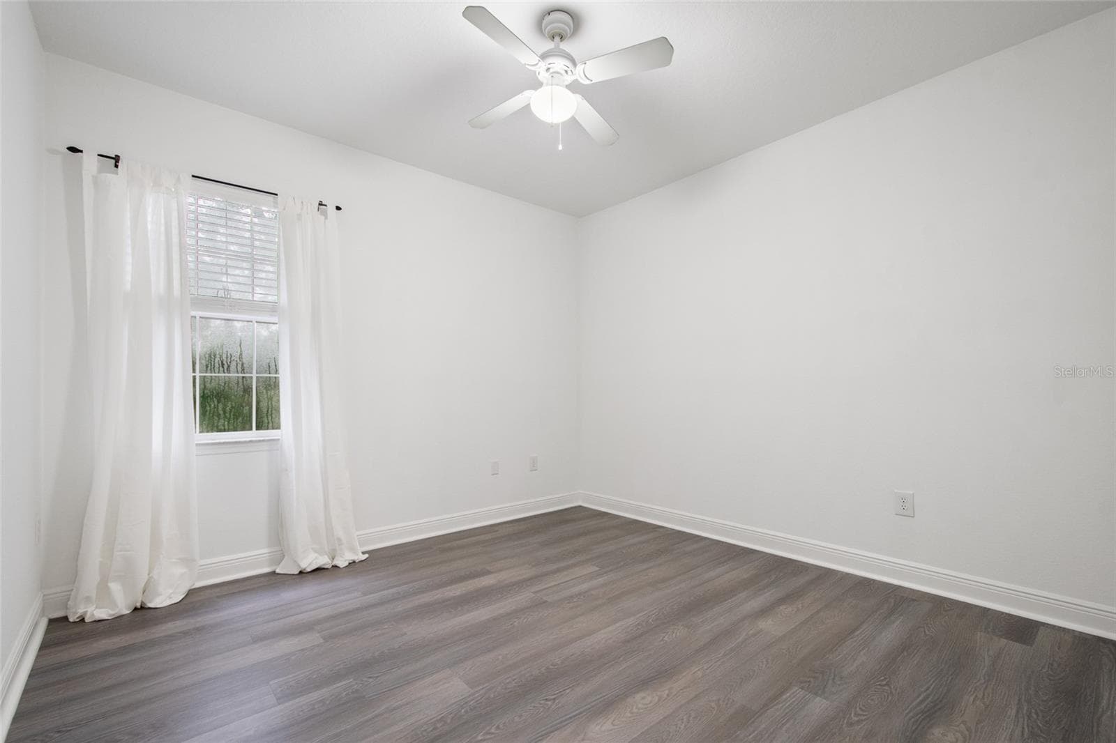 Opposite view of Bedroom 3 towards the window and lovely view of the mature trees. Ceiling fan and drapery rod convey (drapes do not convey) - 1300 EASTERN PECAN PL #208, WINTER GARDEN