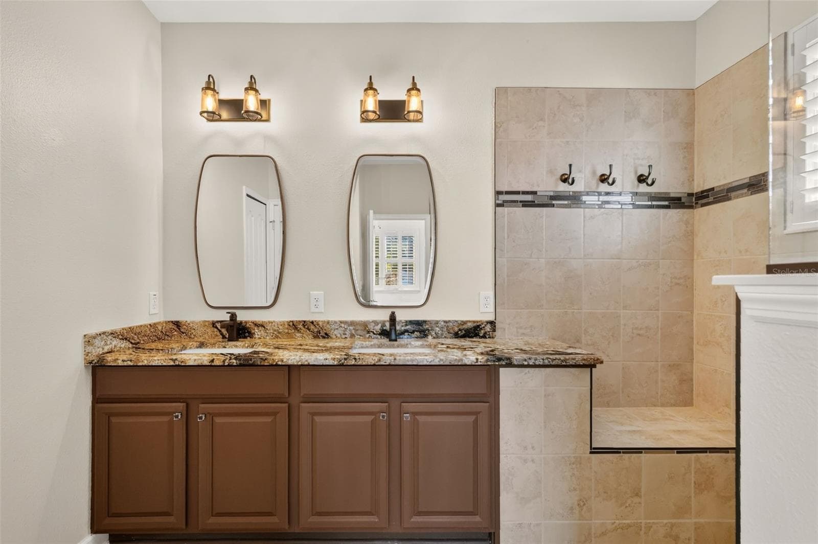 This updated bathroom feels more luxurious, and the built-in shower bench has niche for towel storage ~ - 4913 ROYCE DR, MOUNT DORA