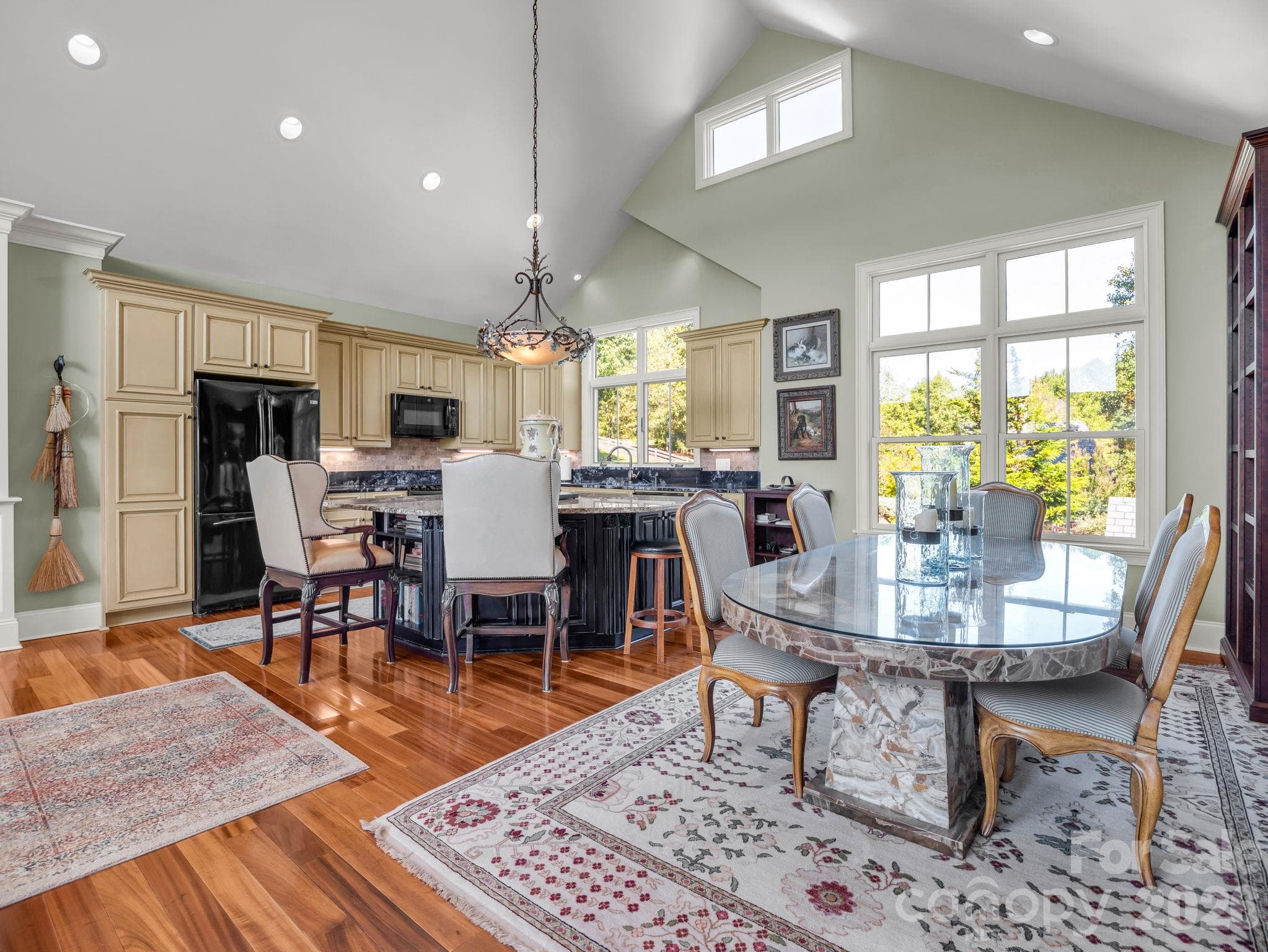 View from the kitchen into the living room and the back of the home, mountain views and see-through fireplace into the primary bedroom - 140 Blazing Star Lane, Mill Spring