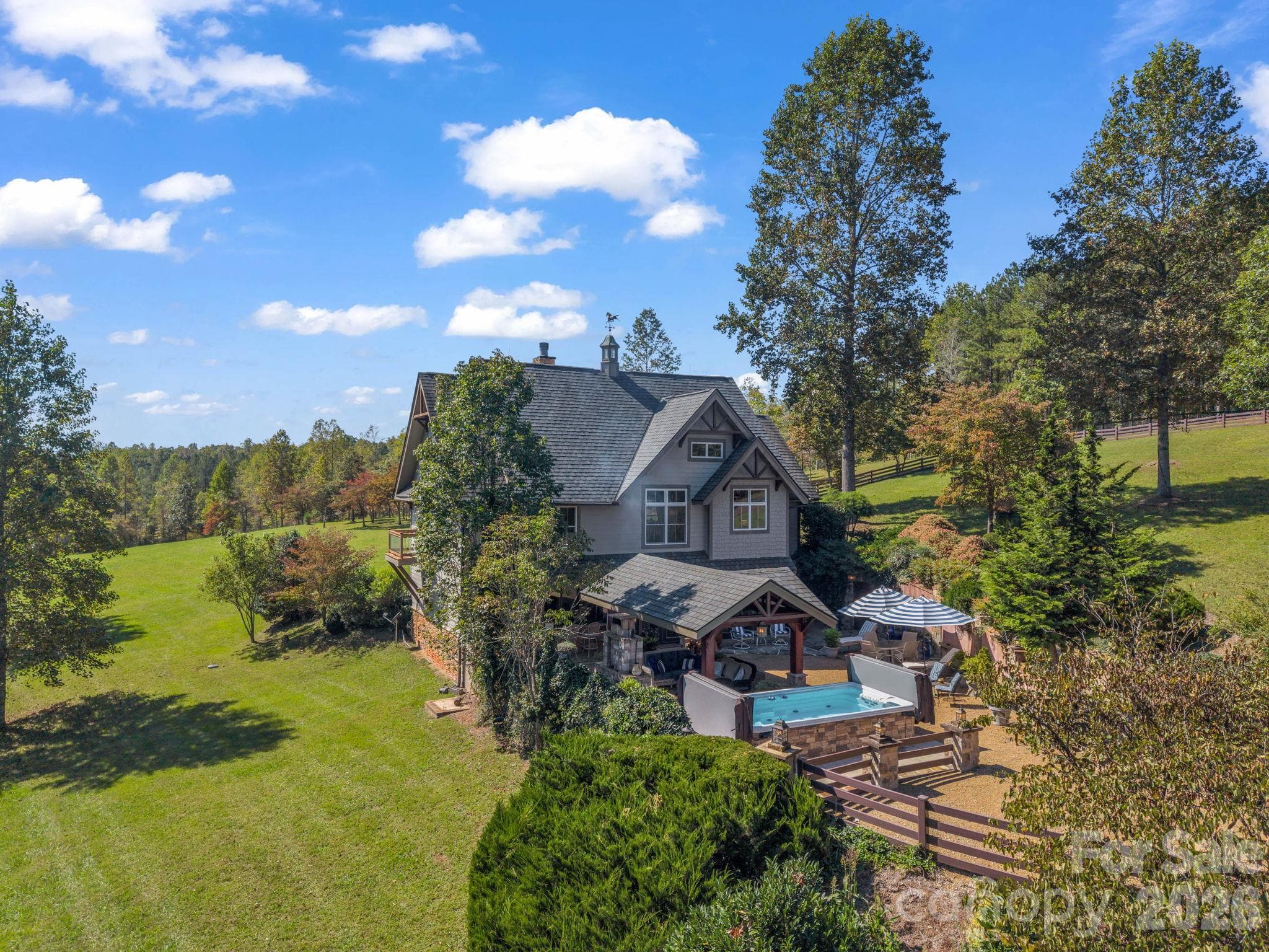 Aerial showing home with the pavilion, fireplace, swim spa and acreage/pastures - 140 Blazing Star Lane, Mill Spring