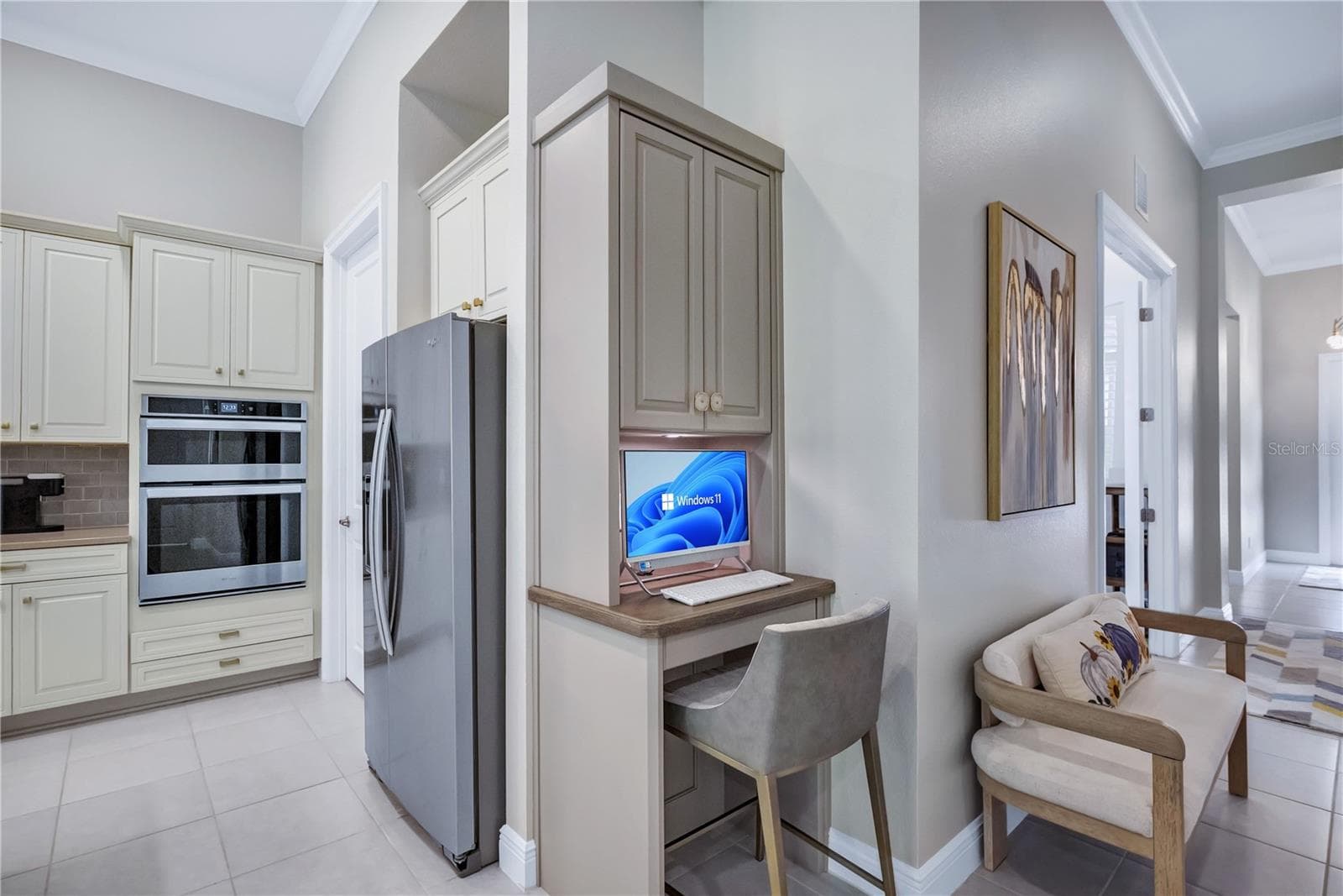Convenient built-in computer workstation located just off the kitchen, featuring custom cabinetry and a dedicated workspace perfect for everyday tasks, organization, or working from home. - 15749 CUTTER SAIL PL, WINTER GARDEN
