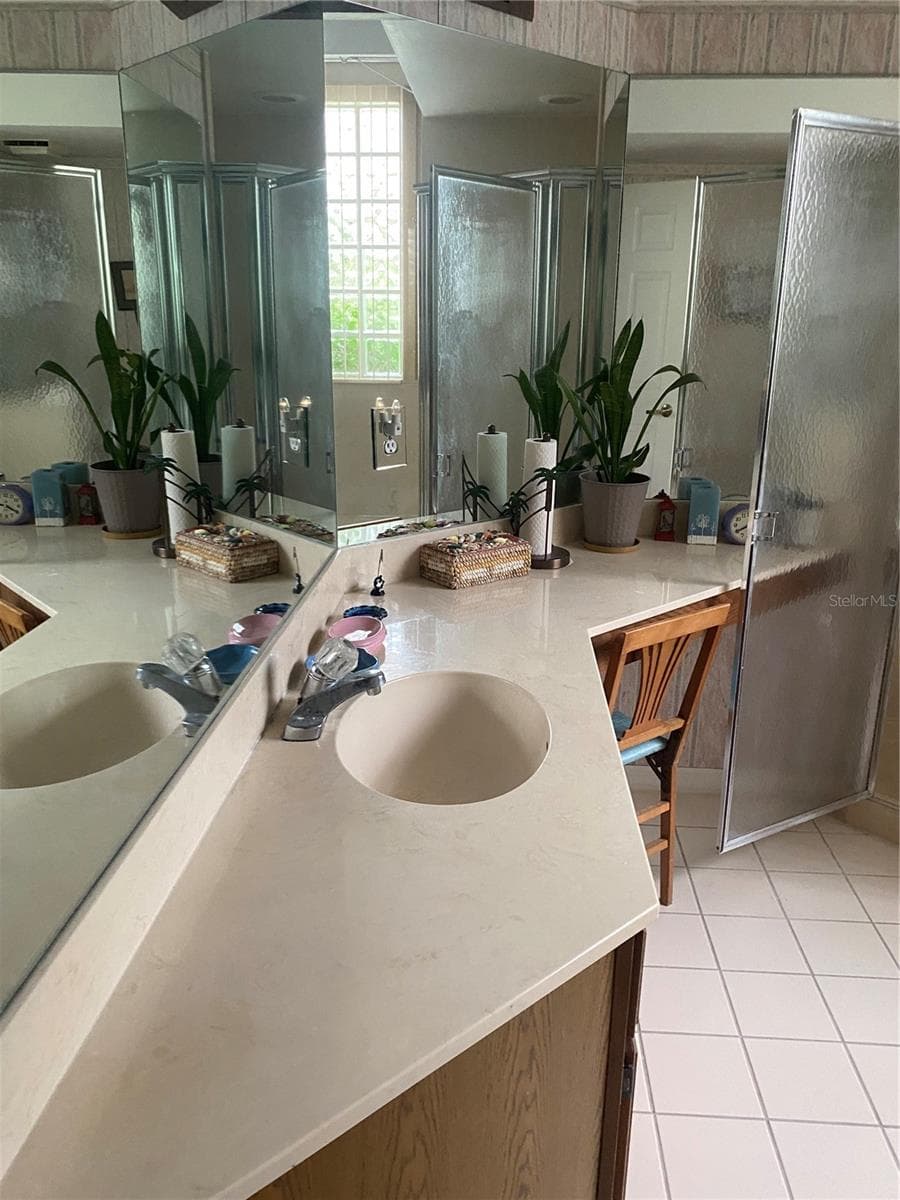 Primary bathroom upgrade countertops, vanity area with chair sitting area. Walk in showder with tub separate area. - 11492 SW 82ND COURT RD, OCALA