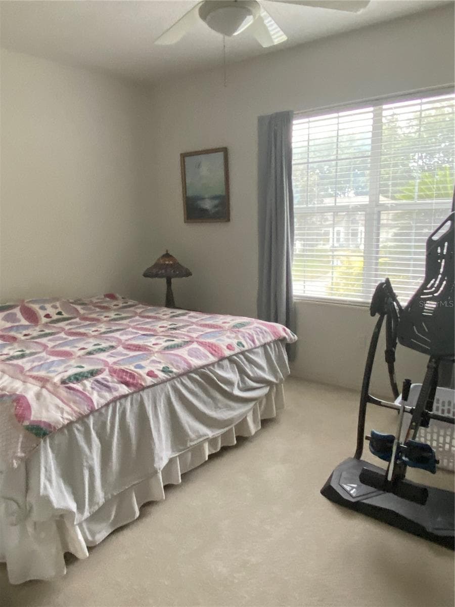 2nd guest bedroom, clean carpet, high ceiling, ceiling fan with lights, large window that brings natural lighting. - 11492 SW 82ND COURT RD, OCALA