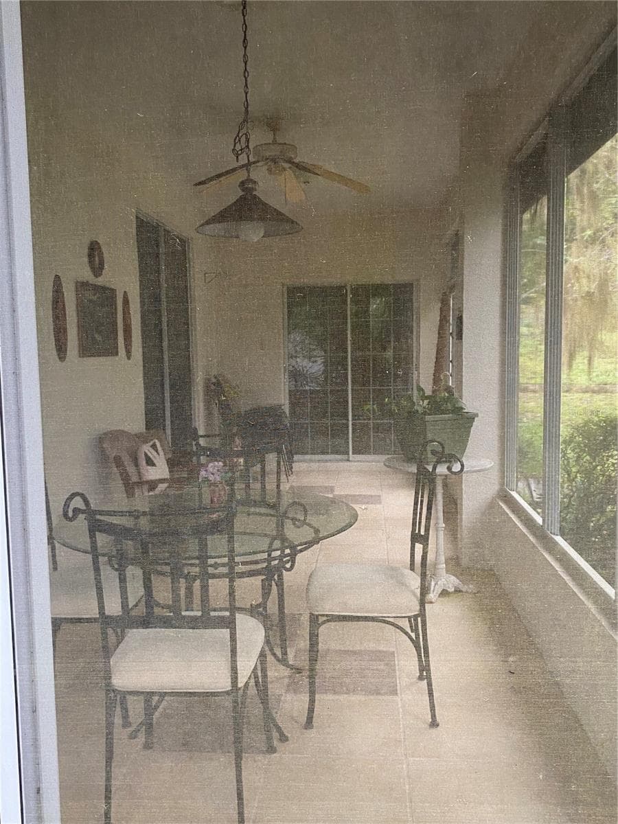 Screened in lanai with ceiling fan and lighting, tiles flooring long access from the kitchen and living area. - 11492 SW 82ND COURT RD, OCALA