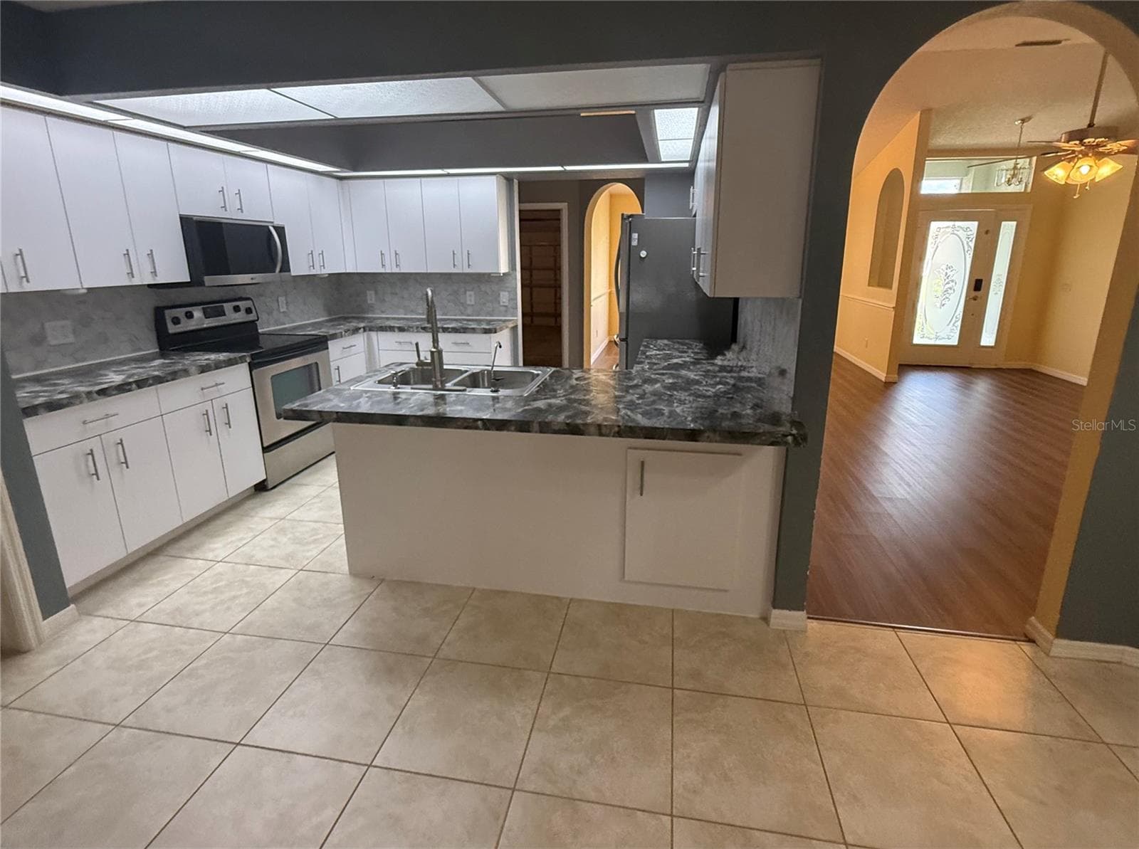 Kitchen with eat at counters. View of Living Room. - 4055 ALLURE LN, NORTH PORT