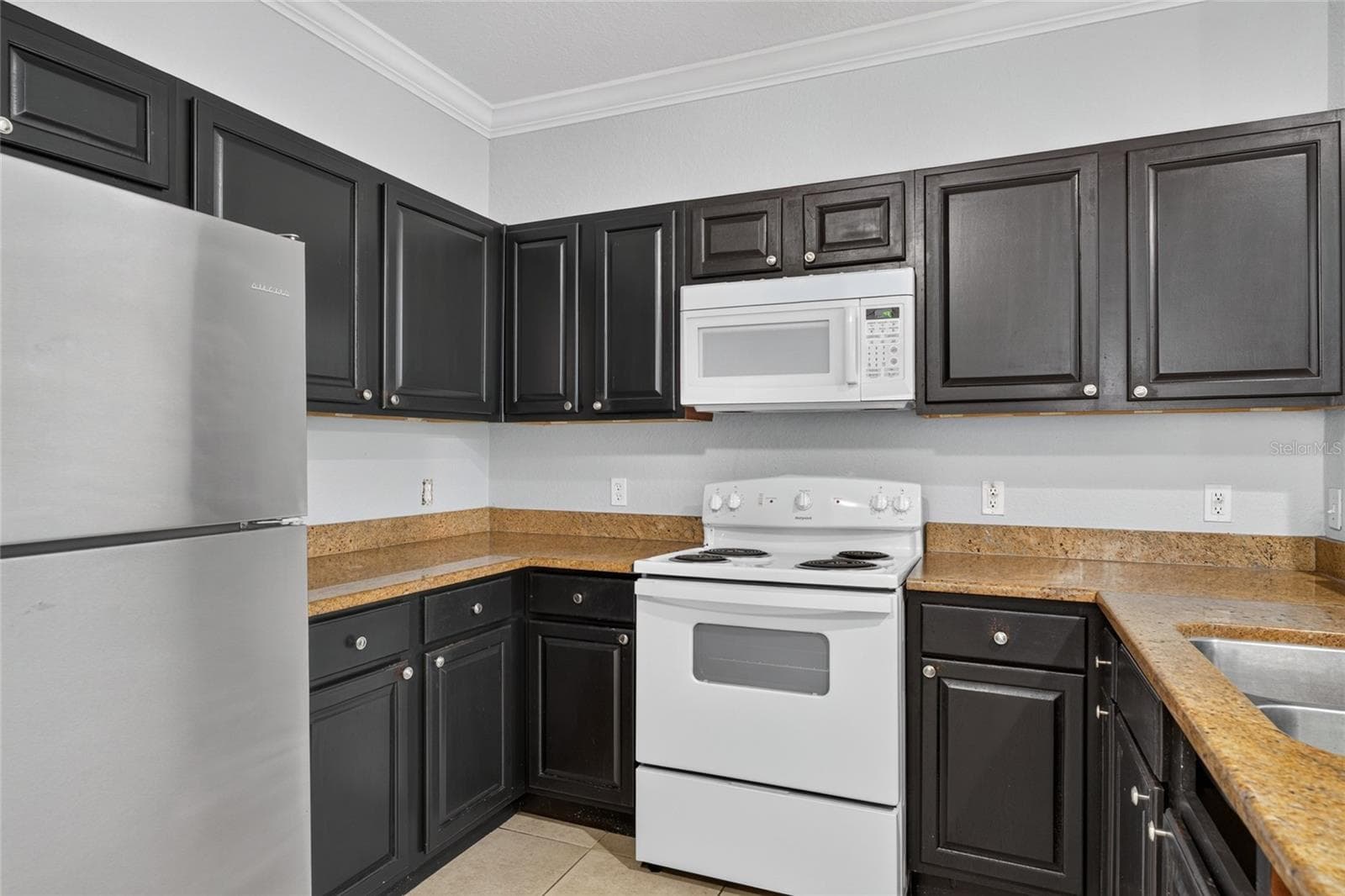KITCHEN. Appliances include: Refrigerator, stove/oven, microwave. No dishwasher. - 1351 TUSCAN TER #8104, DAVENPORT