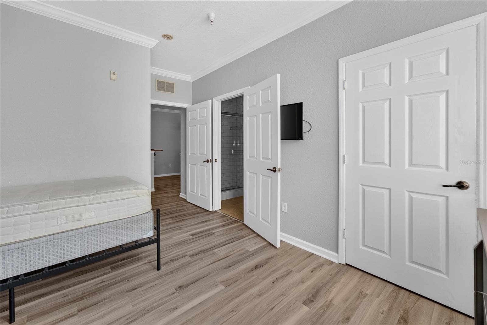 PRIMARY EN SUITE. TV ON WALL. Full bath (left door), and built in closet (door on right). - 1351 TUSCAN TER #8104, DAVENPORT