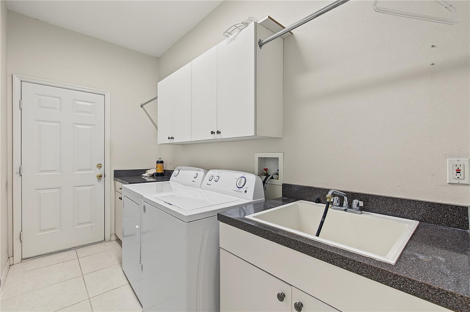 Laundry room and sink coming in from the garage. - 915 LAKE THOMAS LN, LUTZ