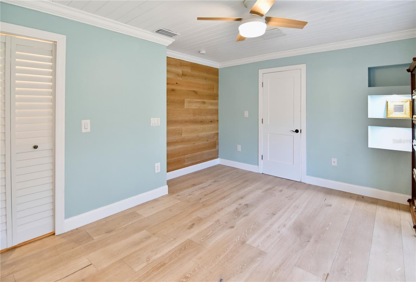 Versatile downstairs bedroom with updated flooring, ceiling fan, and built-in storage. - 1611 CHESTNUT AVE, WINTER PARK