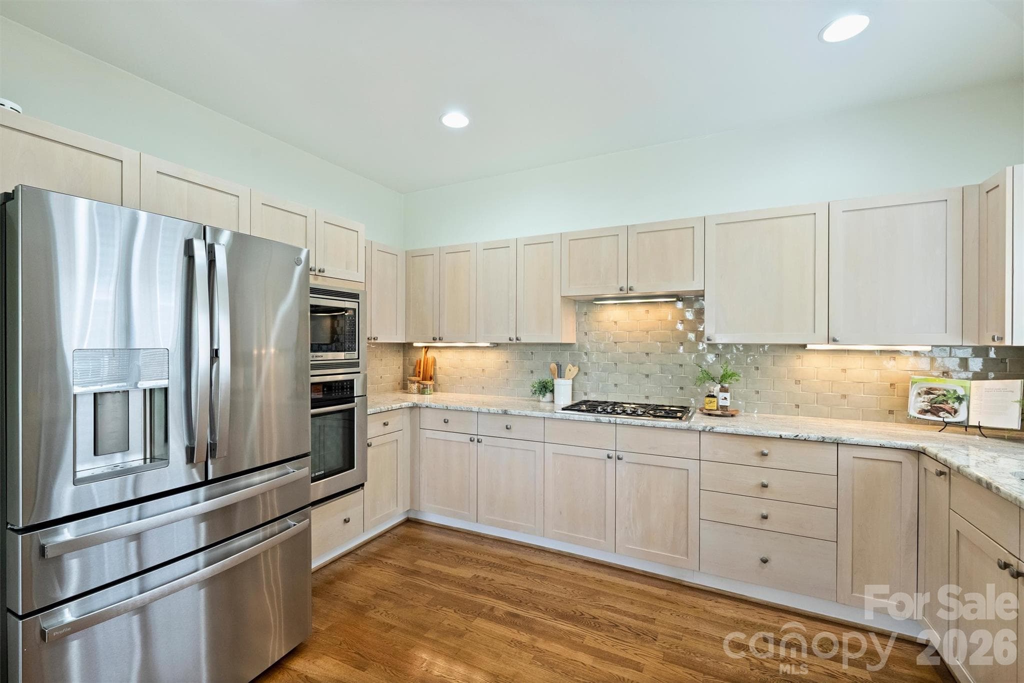 This photo shows off the solid maple cabinets, subway tile backsplash, exotic granite countertops, and under-counter lighting. - 201 Hillside Avenue, Charlotte
