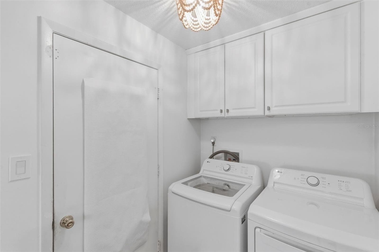 Laundry room with upper cabinets. Washer & Dryer 2025 - 4642 SAINT LAWRENCE DR, NEW PORT RICHEY