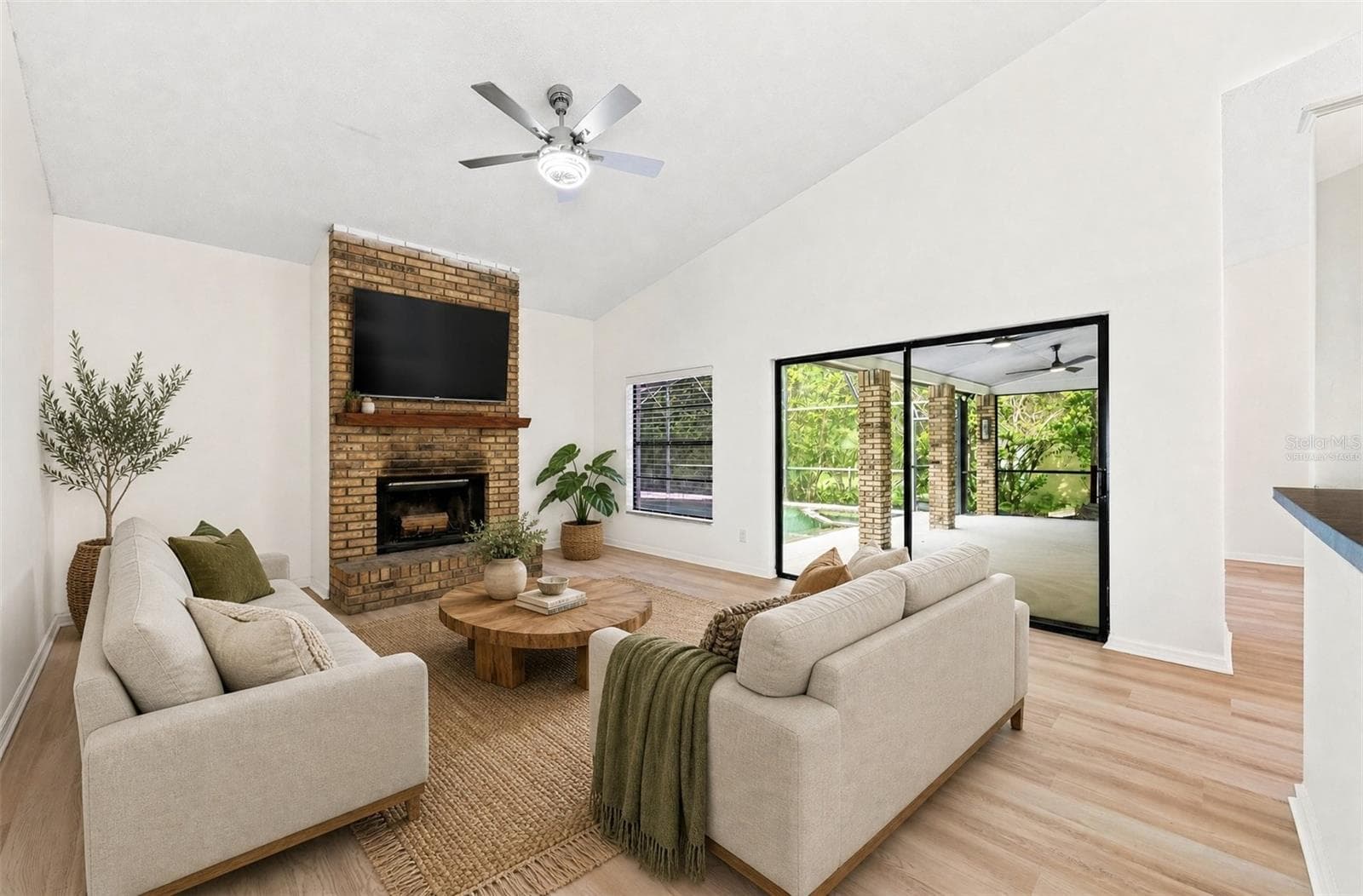 In the Family Room, a WOOD-BURNING FIREPLACE creates a cozy focal point, and sliding glass doors provide another EASY CONNECTION to the outdoor living space. Virtually Staged - 1003 N MAGEE CREEK CT, OVIEDO
