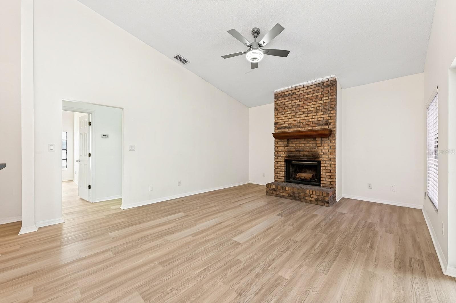 In the Family Room, a WOOD-BURNING FIREPLACE creates a cozy focal point, and sliding glass doors provide another EASY CONNECTION to the outdoor living space. - 1003 N MAGEE CREEK CT, OVIEDO