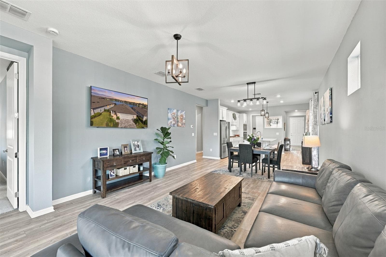 Great View of Living to Dining to Kitchen. Showing Luxury Vinyl Plank Flooring throughout the living areas and updated lighting. - 9260 BALLASTER POINTE LOOP, PARRISH