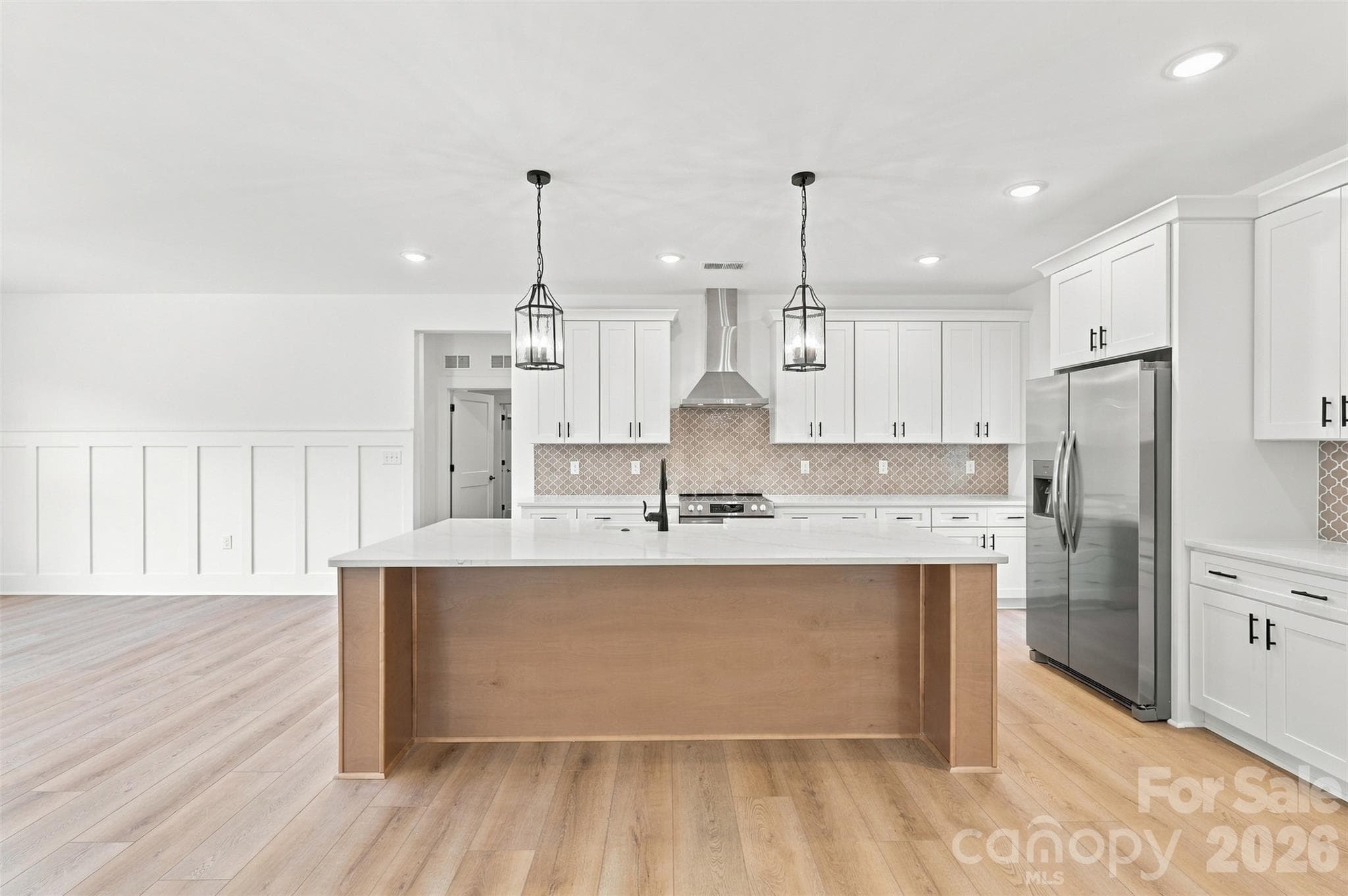 Kitchen- thoughtfully selected countertops, cabinetry, & backsplash. Walk-in pantry (w/ wood shelves!). Large island w/ porcelain farmhouse sink. Stainless steel hood vent. - 394 S NC 200 Highway, Stanfield