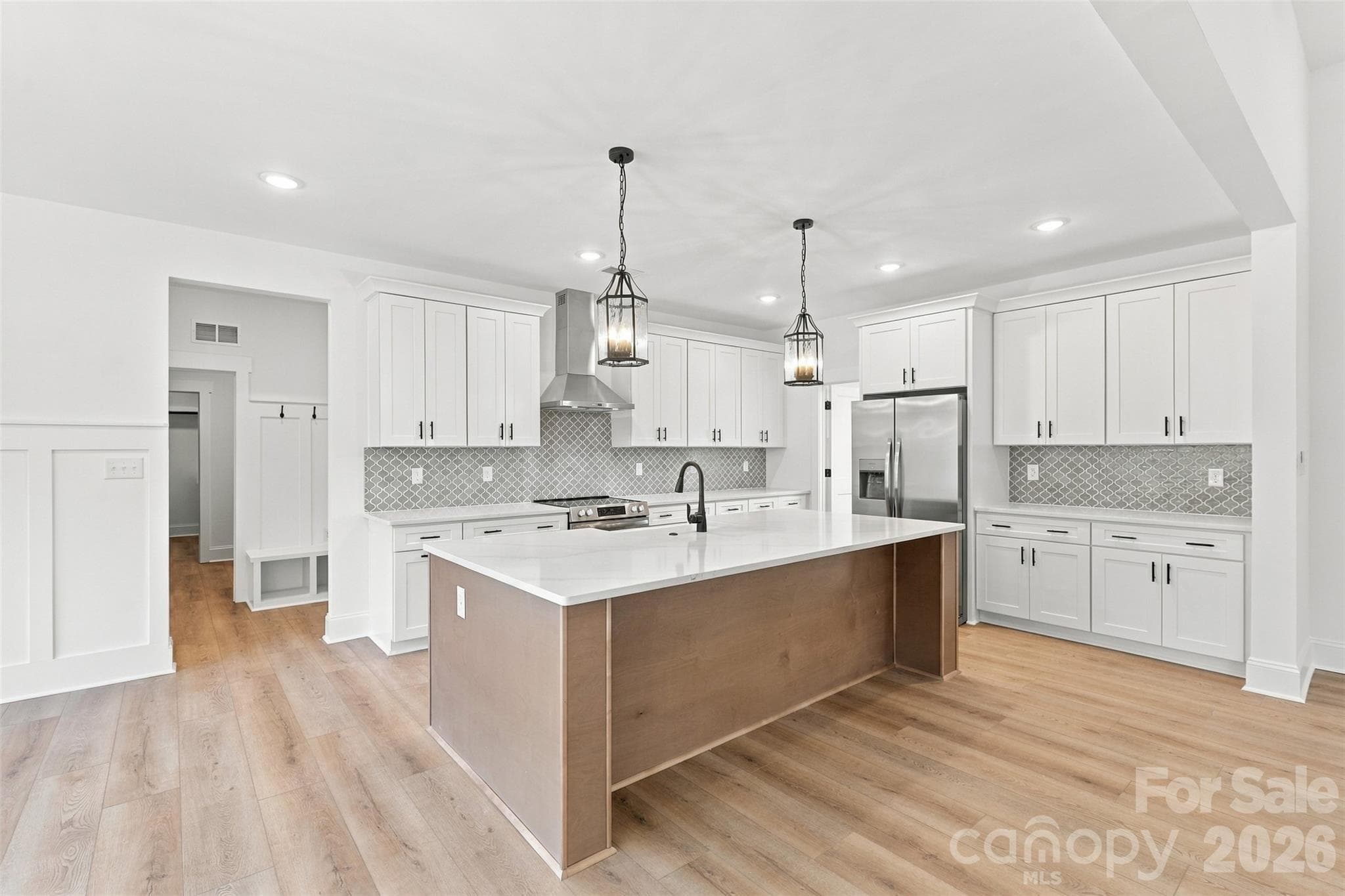 Kitchen- thoughtfully selected countertops, cabinetry, & backsplash. Walk-in pantry (w/ wood shelves!). Large island w/ porcelain farmhouse sink. Stainless steel hood vent. - 394 S NC 200 Highway, Stanfield
