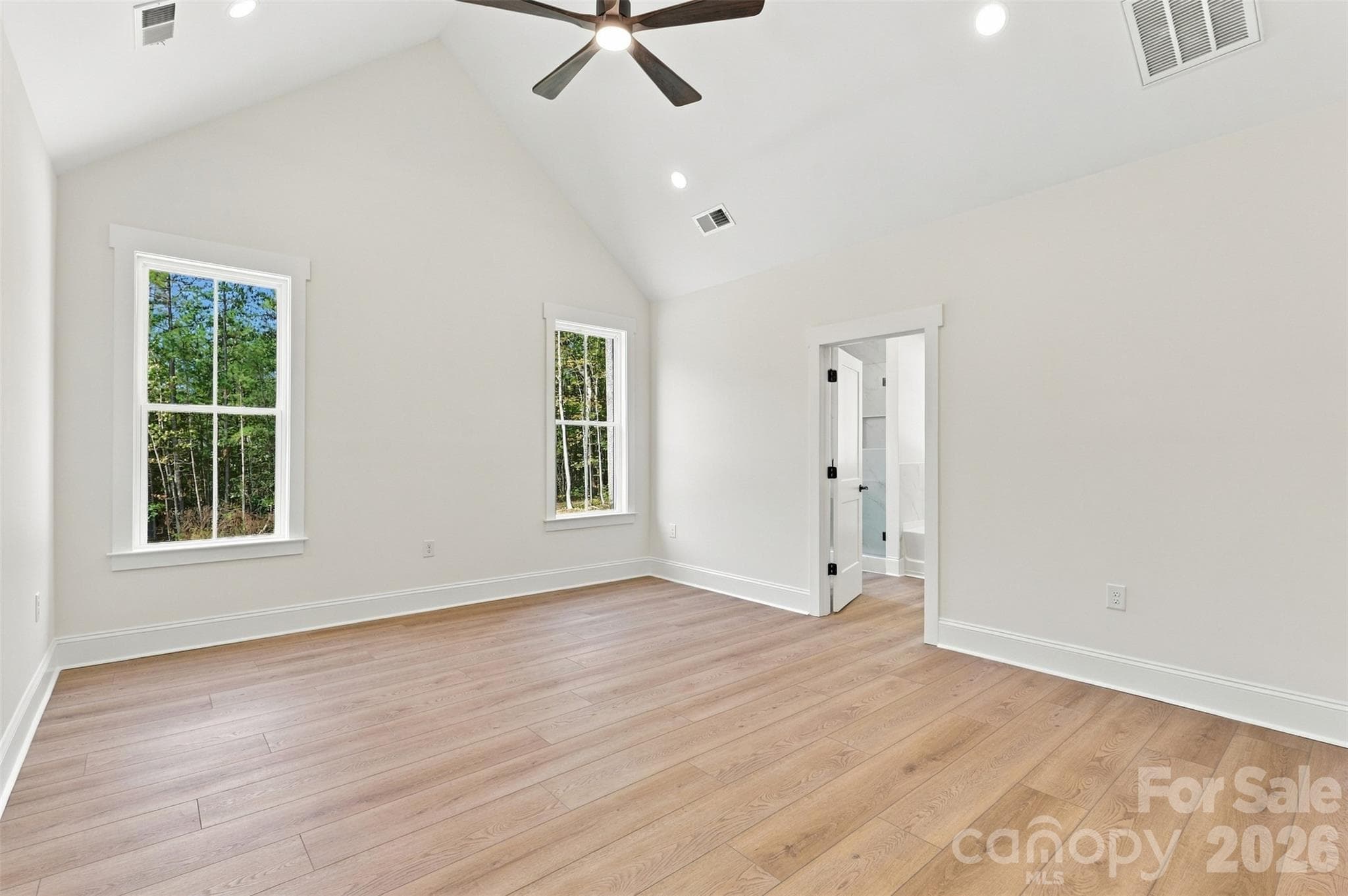 Primary bedroom- vaulted ceiling, ensuite bathroom with: dual vanities, tiled garden tub, tiled shower, commode room. Ensuite bath leads into large WIC w/ custom wood shelving and cabinetry! - 394 S NC 200 Highway, Stanfield