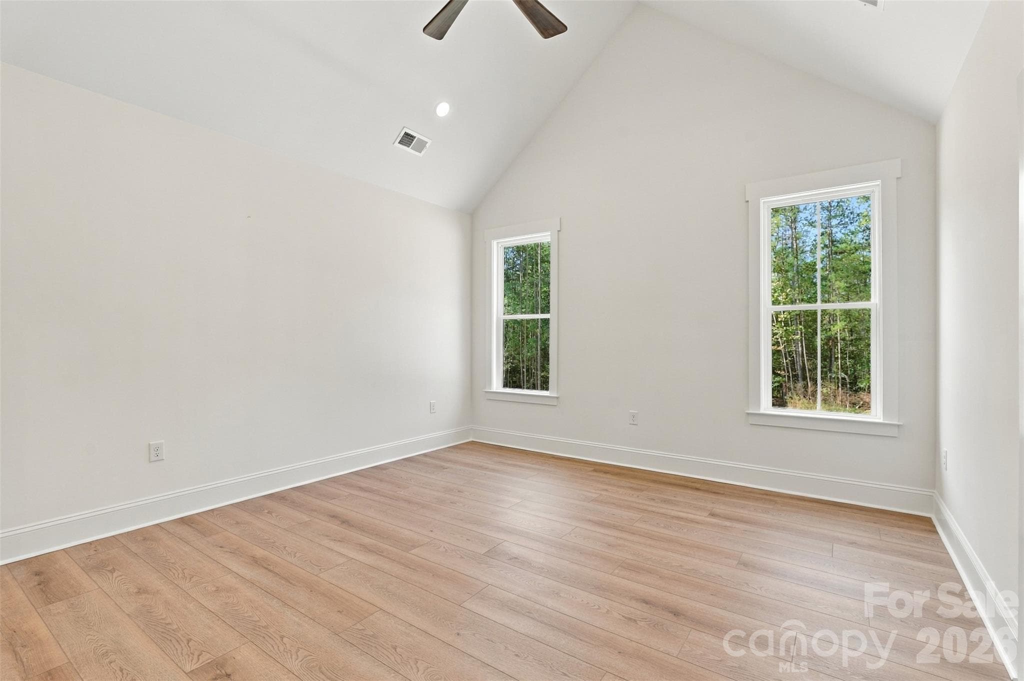 Primary bedroom- vaulted ceiling, ensuite bathroom with: dual vanities, tiled garden tub, tiled shower, commode room. Ensuite bath leads into large WIC w/ custom wood shelving and cabinetry! - 394 S NC 200 Highway, Stanfield