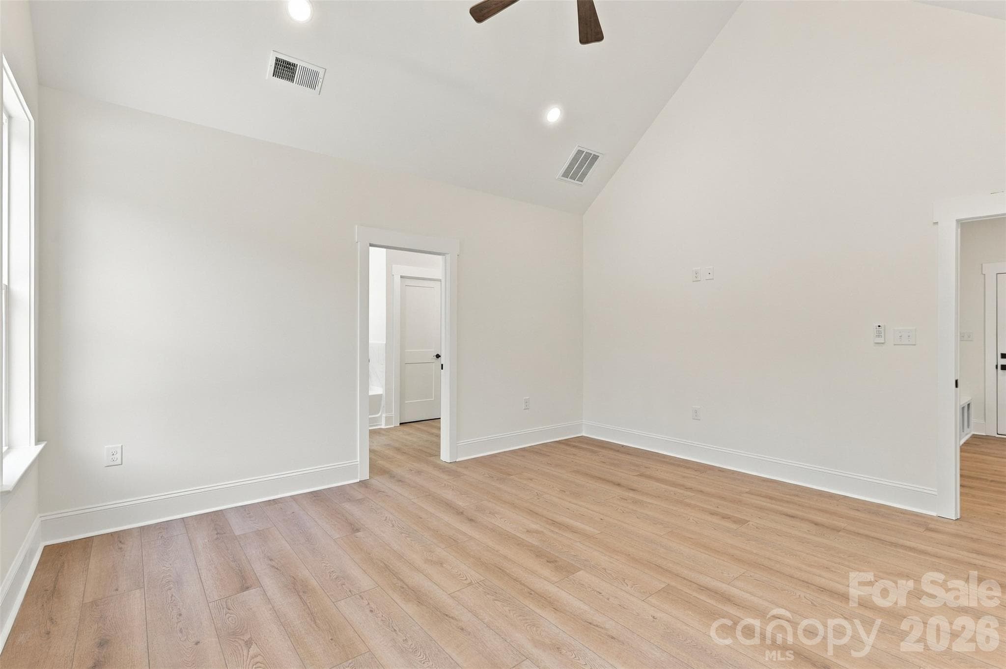 Primary bedroom- vaulted ceiling, ensuite bathroom with: dual vanities, tiled garden tub, tiled shower, commode room. Ensuite bath leads into large WIC w/ custom wood shelving and cabinetry! - 394 S NC 200 Highway, Stanfield
