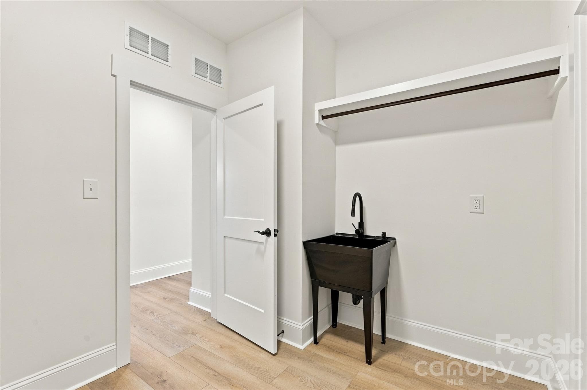 Laundry room- accessed either by hallway or from primary WIC. Utility sink and shelving! - 394 S NC 200 Highway, Stanfield