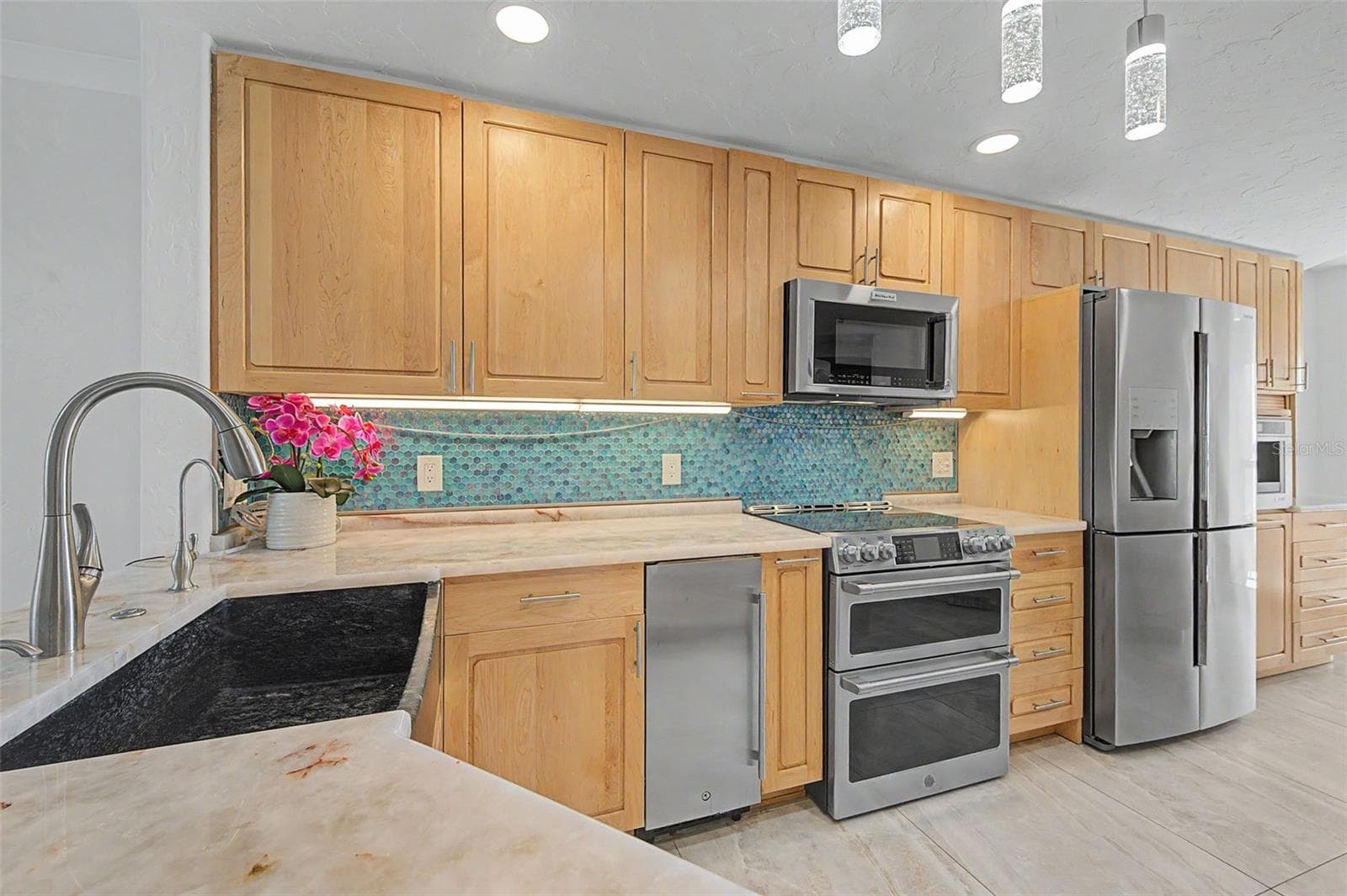 Maple cabinets, quartz counters and tile backsplash - 1310 GULF BLVD #14E, CLEARWATER