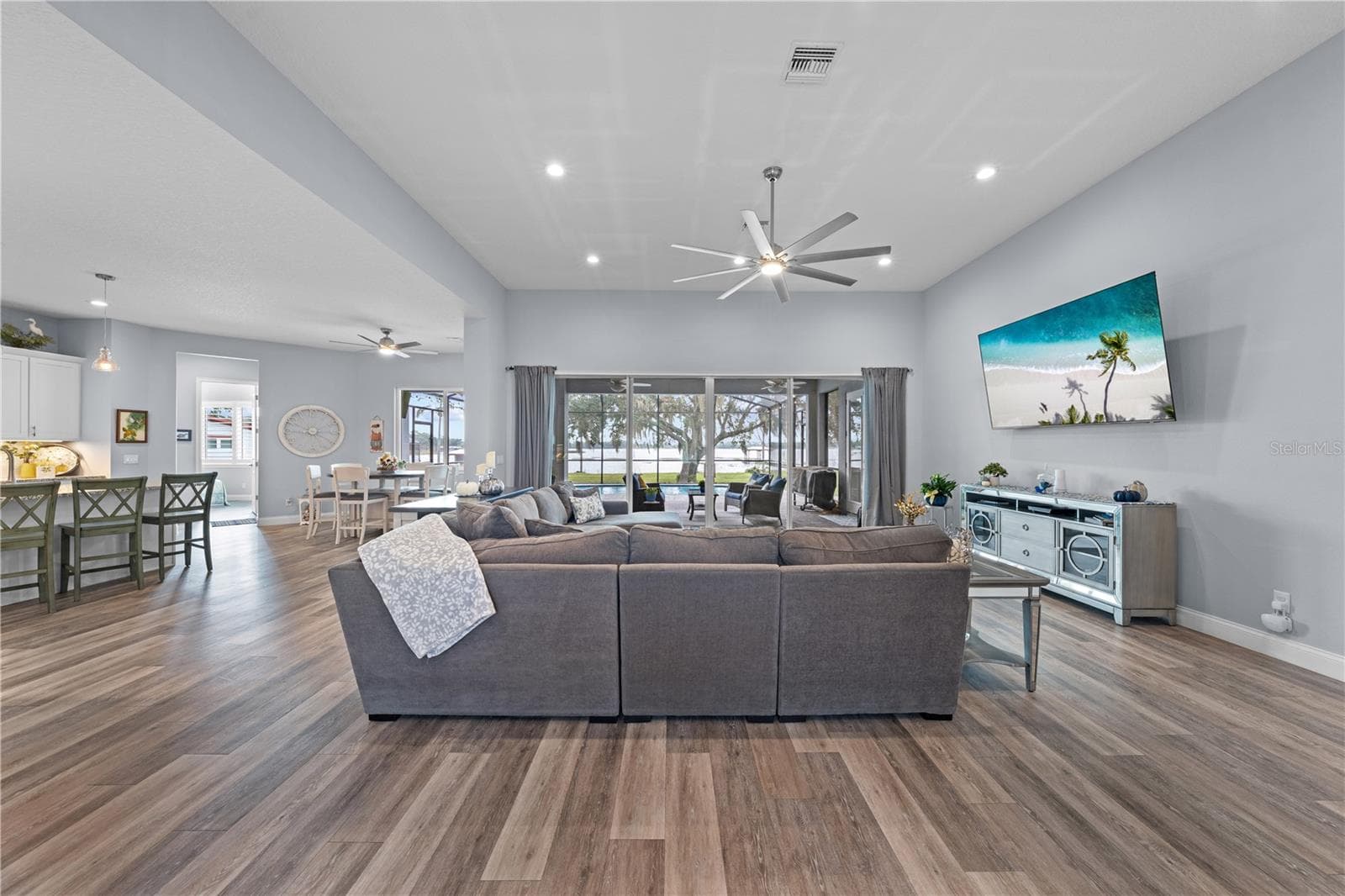 Open floor plan with family room, large ceiling fan and great view of the lake. - 590 EDEN DR, ST CLOUD