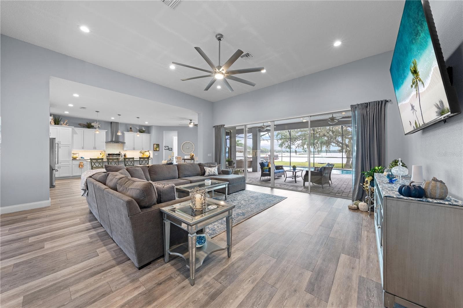 Open floor plan with family room, large ceiling fan and great view of the lake. - 590 EDEN DR, ST CLOUD