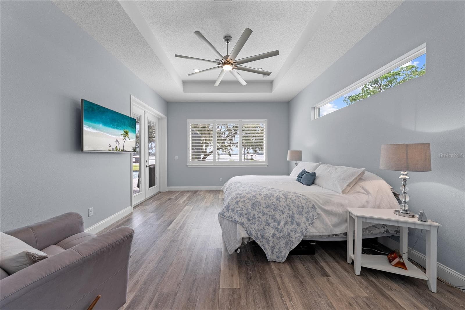 Primary Bedroom with a view of the lake, tray ceiling and double entry doors to the lania - 590 EDEN DR, ST CLOUD