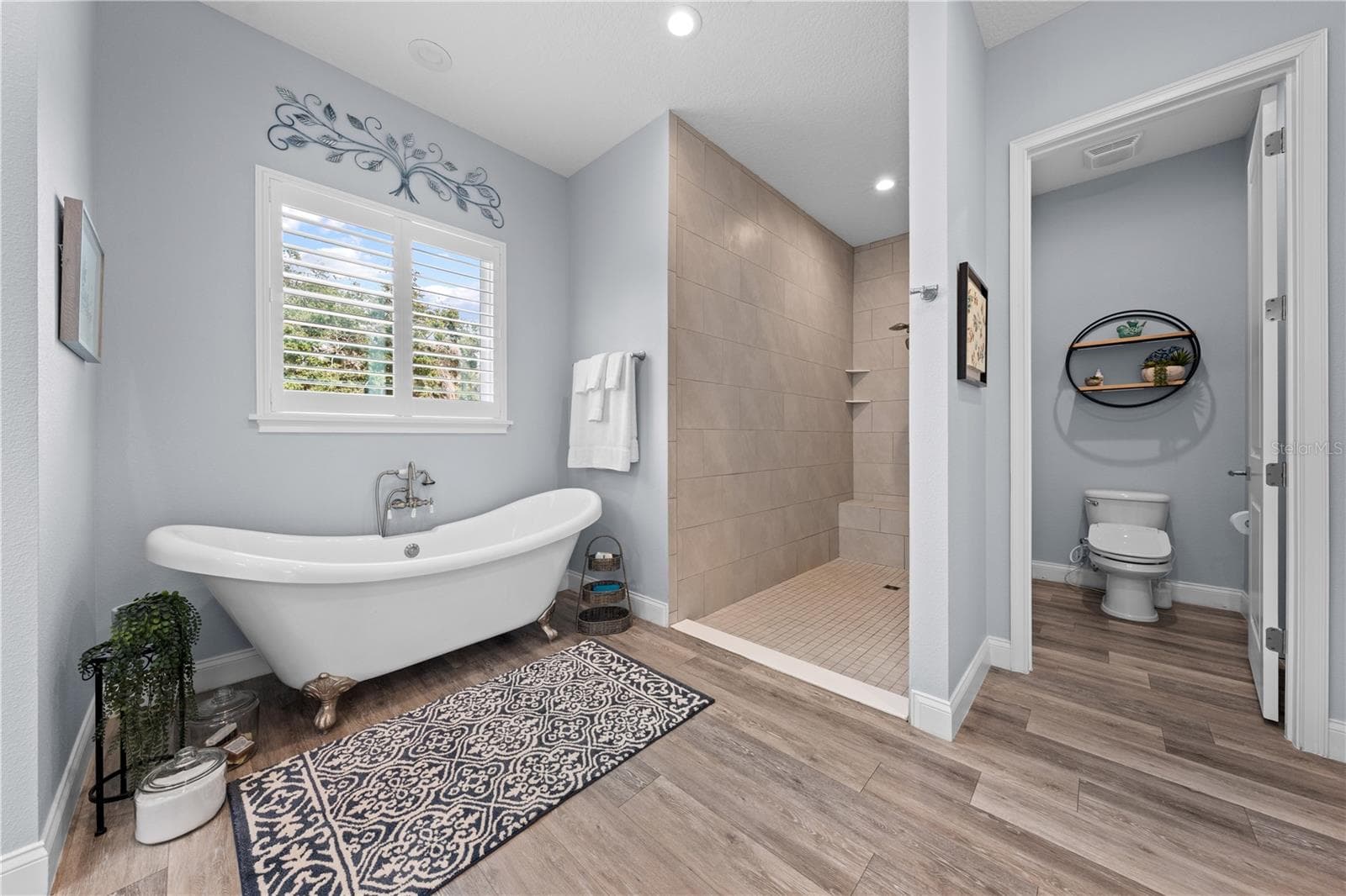 Primary bathroom with large open shower, dual shower head including one rain and private water closet. - 590 EDEN DR, ST CLOUD