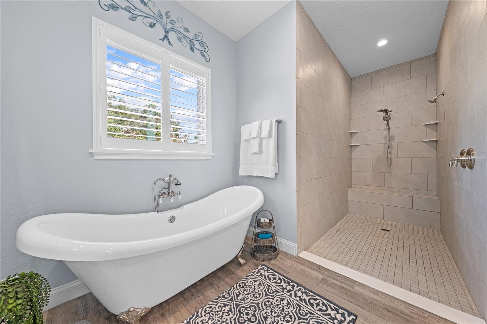Primary bathroom, claw foot tub, large open shower with dual showerhead and sitting bench - 590 EDEN DR, ST CLOUD