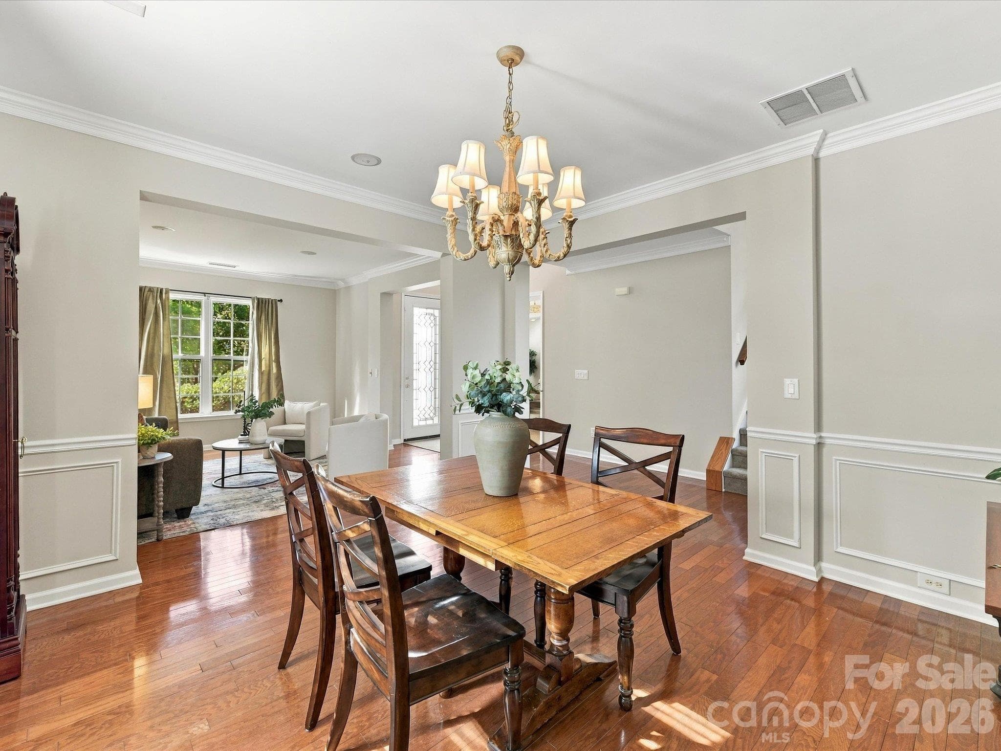 Formal dining room with hardwood floors, classic wainscoting, and abundant natural light, making it the perfect space for hosting holiday gatherings and dinner parties. - 1788 Oakmont Drive, Denver