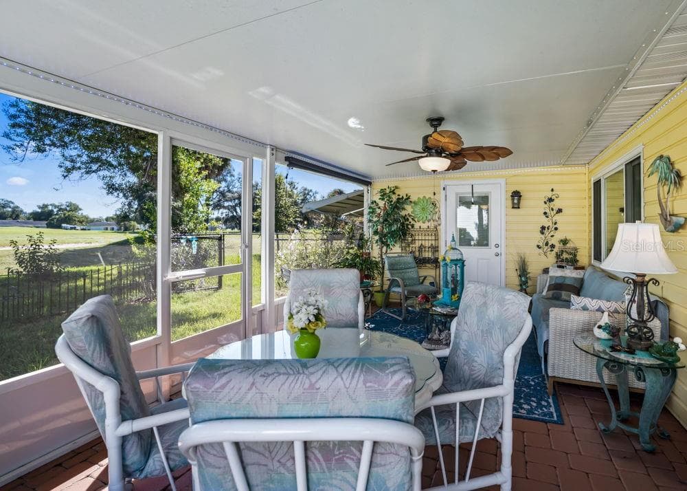 Enjoy golf course and pond views from this spacious screened-in lanai, featuring brick paver flooring, a covered ceiling, and a tropical-style ceiling fan. With room for dining and lounging, it’s an inviting setting for morning coffee or relaxing with friends. - 17909 SE 99TH AVE, SUMMERFIELD