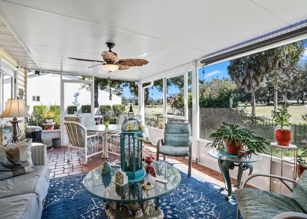 The spacious rear screened lanai overlooks The Links golf course and nearby pond, offering a peaceful setting for morning coffee or entertaining. Brick-paver flooring, a tropical-style ceiling fan, and ample room for dining and lounging create an inviting outdoor retreat. - 17909 SE 99TH AVE, SUMMERFIELD